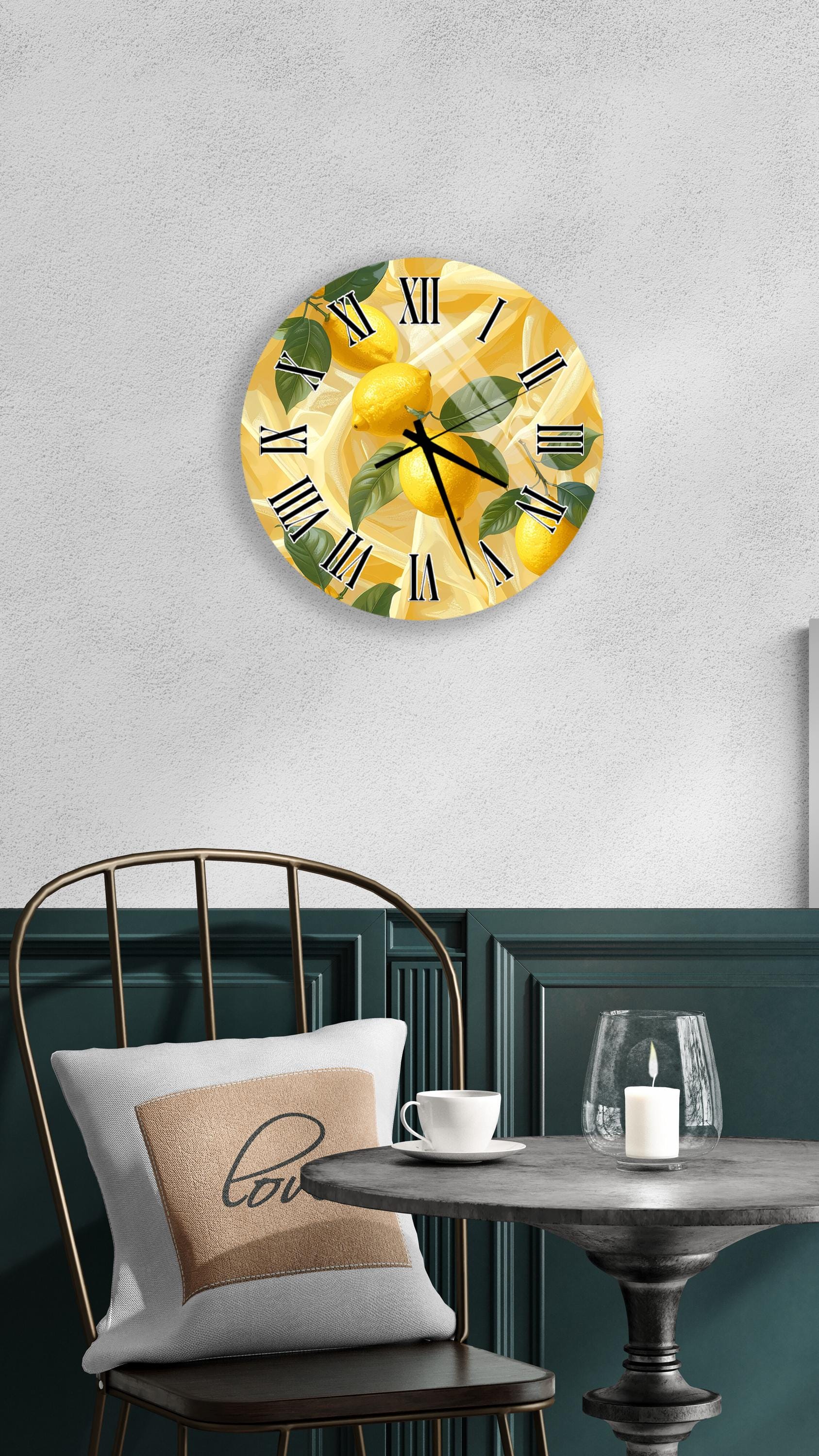 a wall clock with a lemon design, a white table with a candle and a cup, and a black chair with a pillow.