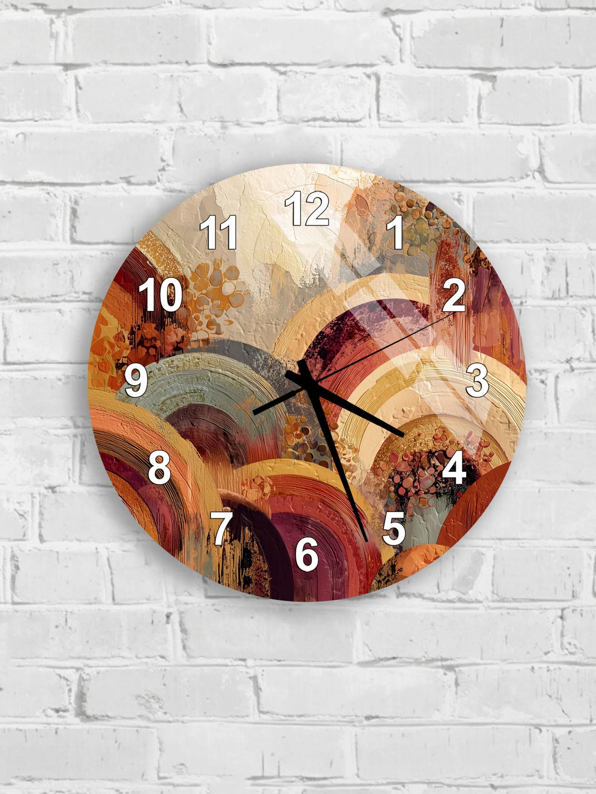 A wall clock with a colorful abstract design on its face, mounted on a white brick wall.