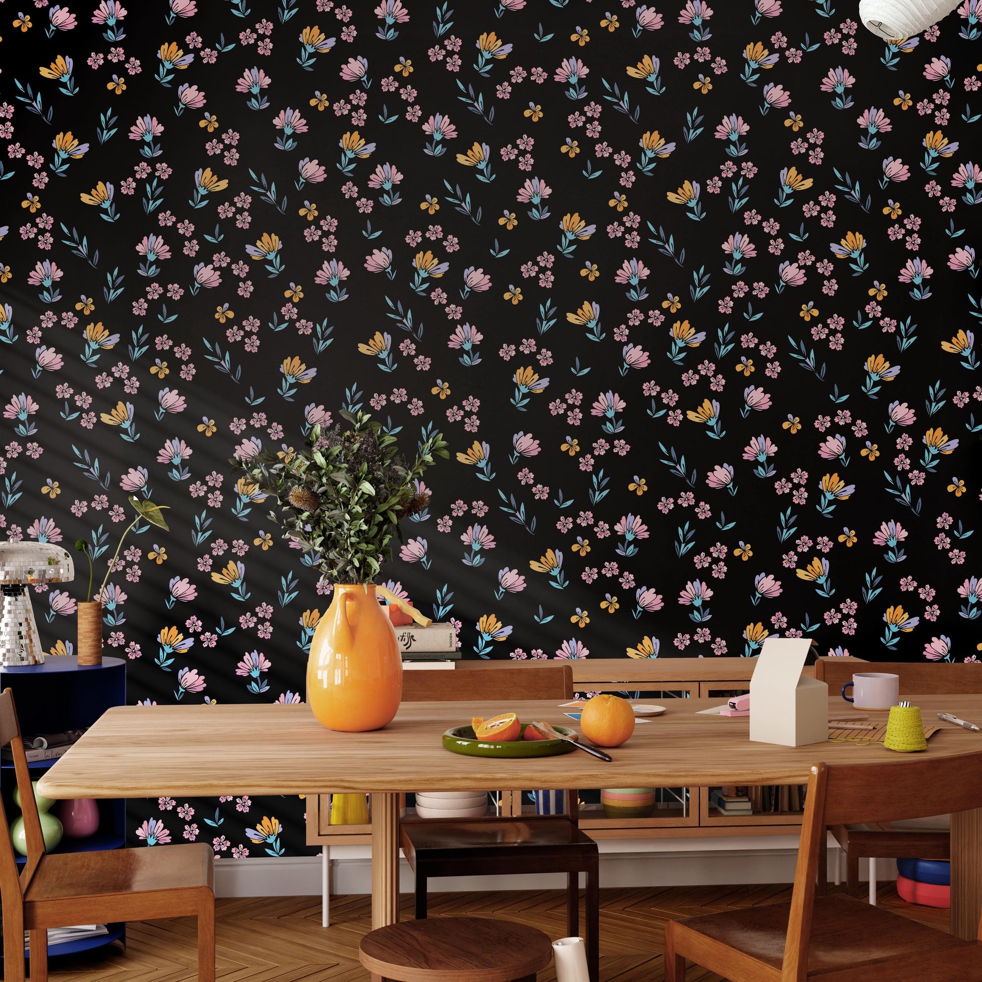 a dining room with a wooden table set for a meal, featuring a vase of flowers, a bowl of fruit, and a plate of food. The walls are adorned with a floral pattern, and the room is furnished with wooden chairs and tables.