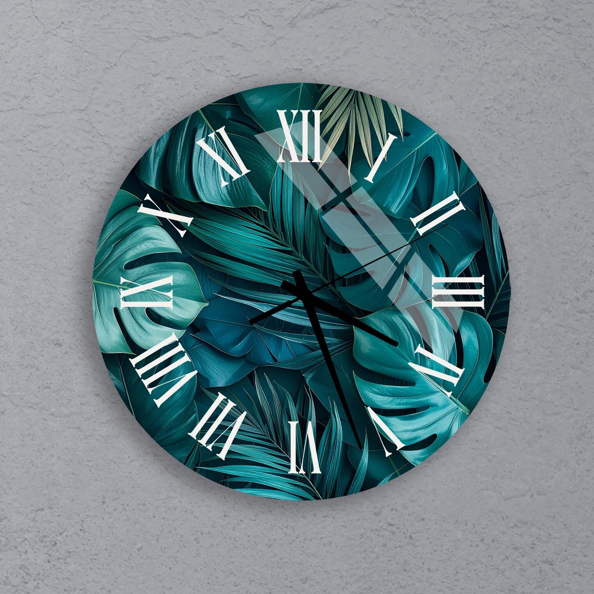 A round wall clock with a tropical leaf pattern on its face.