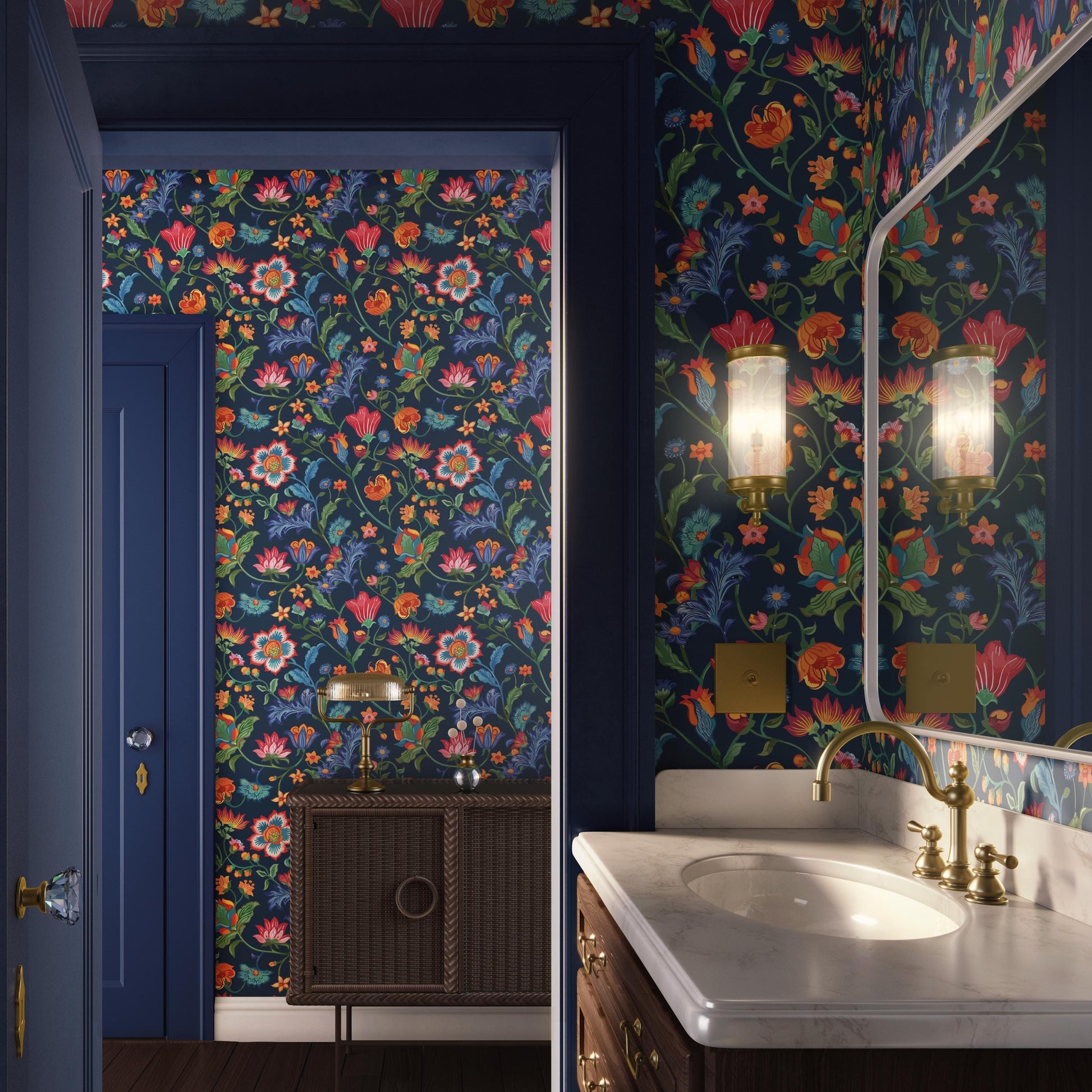 a bathroom with a floral wallpaper, a white sink, and a wooden vanity with a lamp. The walls are covered in a vibrant, colorful floral pattern, creating a lively and cheerful atmosphere.