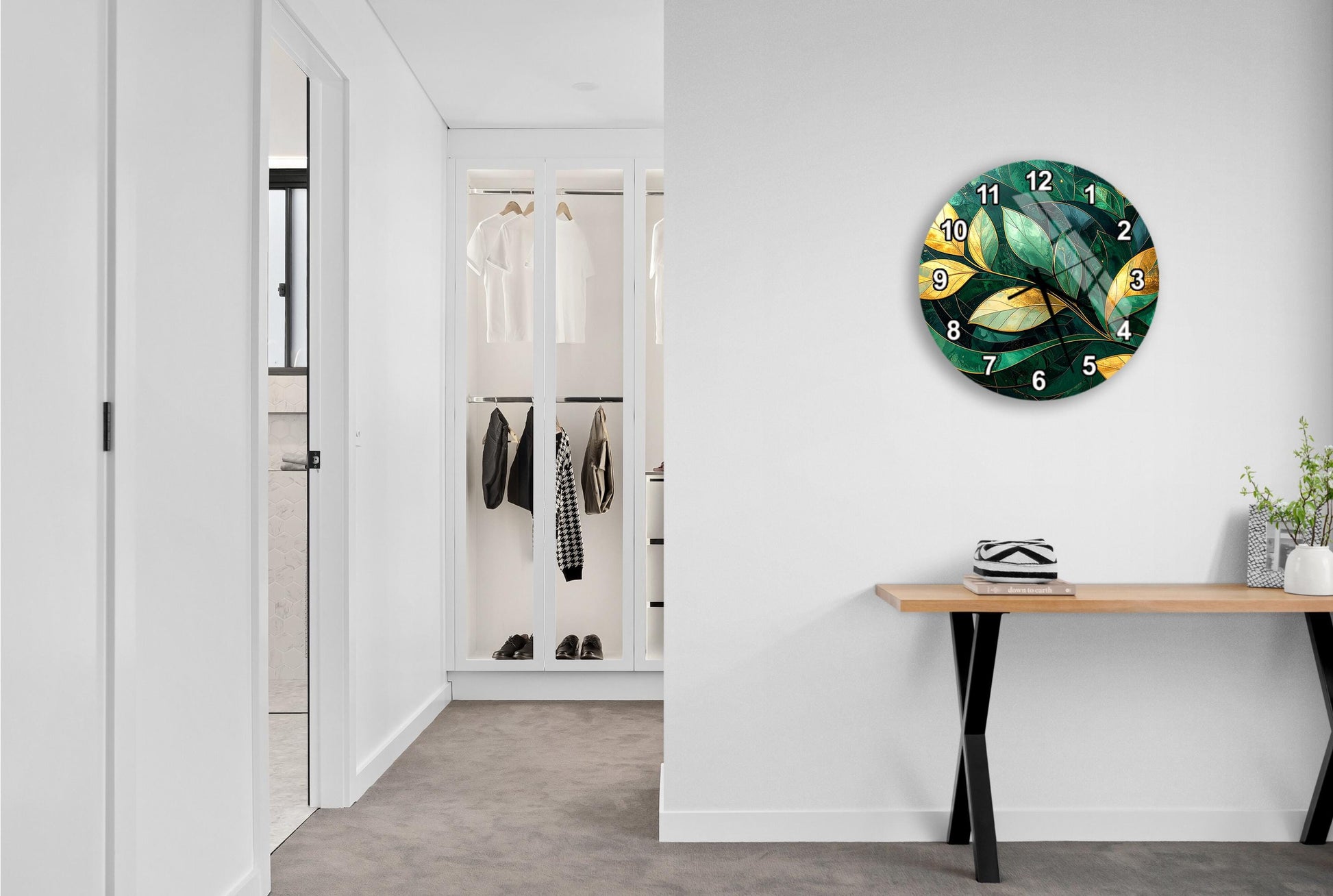 a hallway with a large clock on the wall, a wooden table, and a closet with hanging clothes.