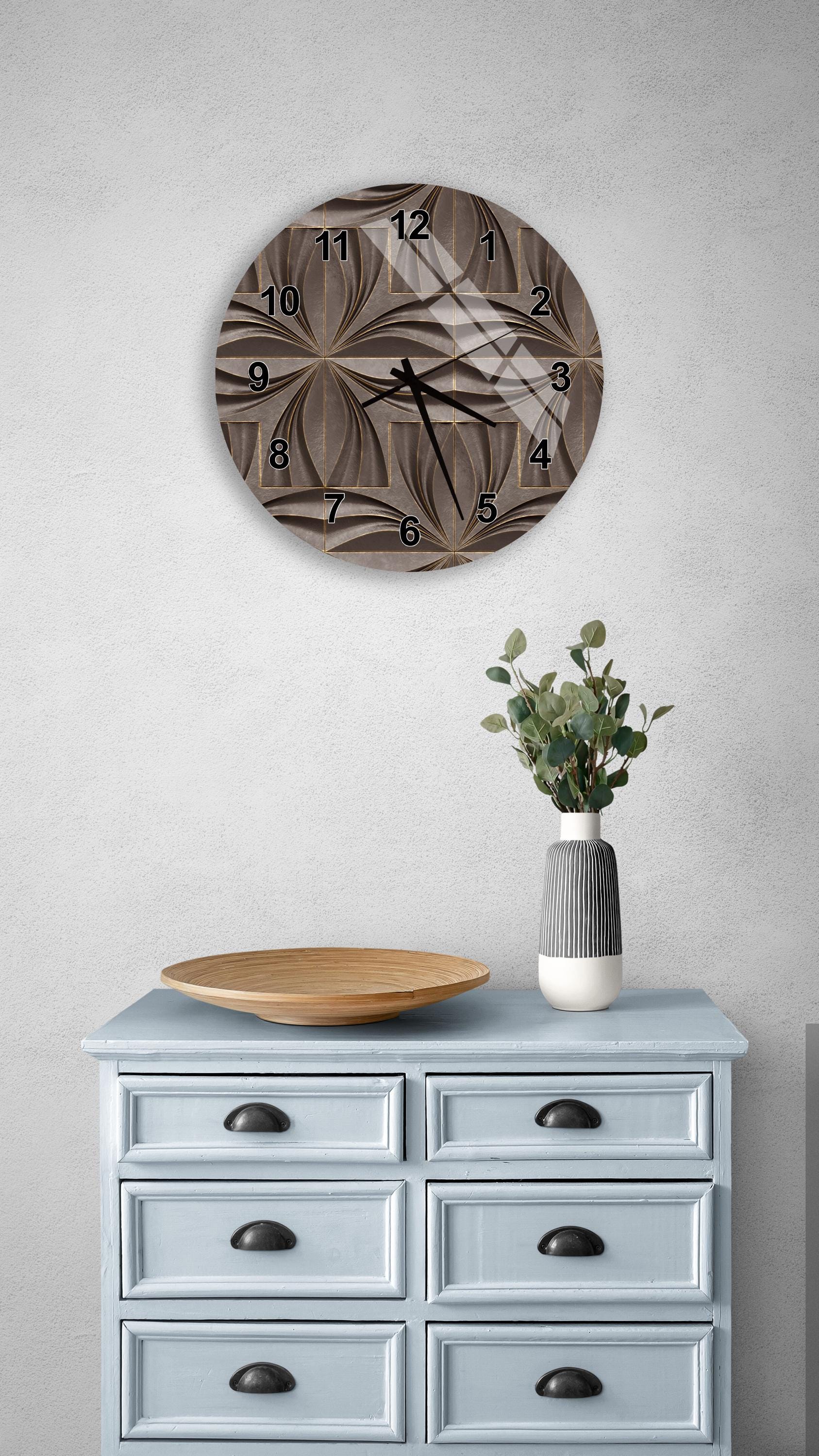 a wall clock with a unique, abstract design, a wooden tray, a vase with greenery, and a light blue dresser with six drawers.