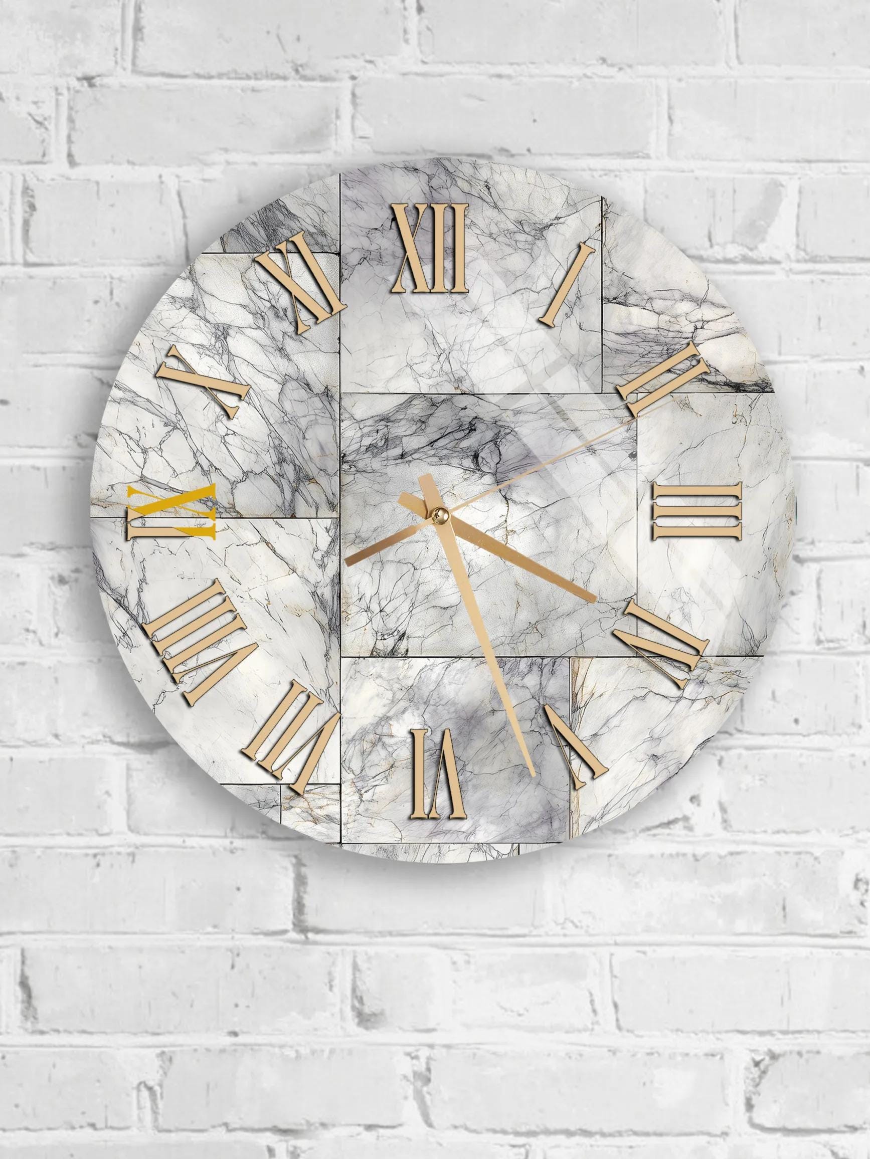 A round wall clock with Roman numerals and gold hands is mounted on a white brick wall.