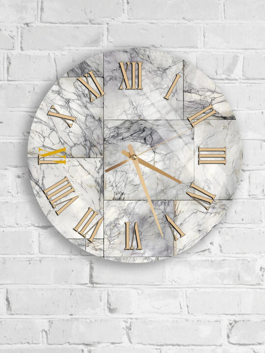 A round wall clock with Roman numerals and gold hands is mounted on a white brick wall.