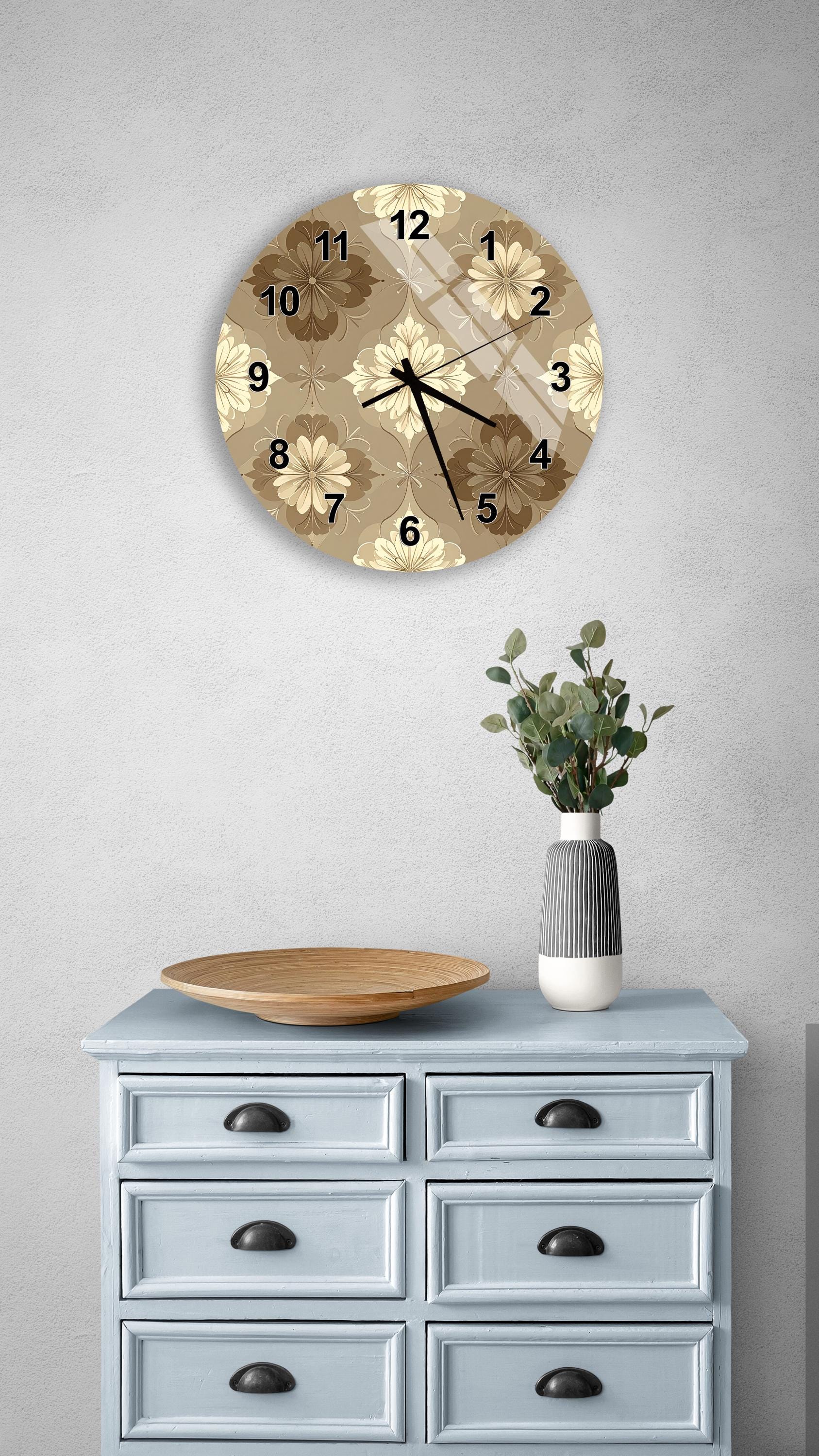 a wall clock with a floral pattern, a wooden tray, a vase with greenery, and a light blue dresser with six drawers.