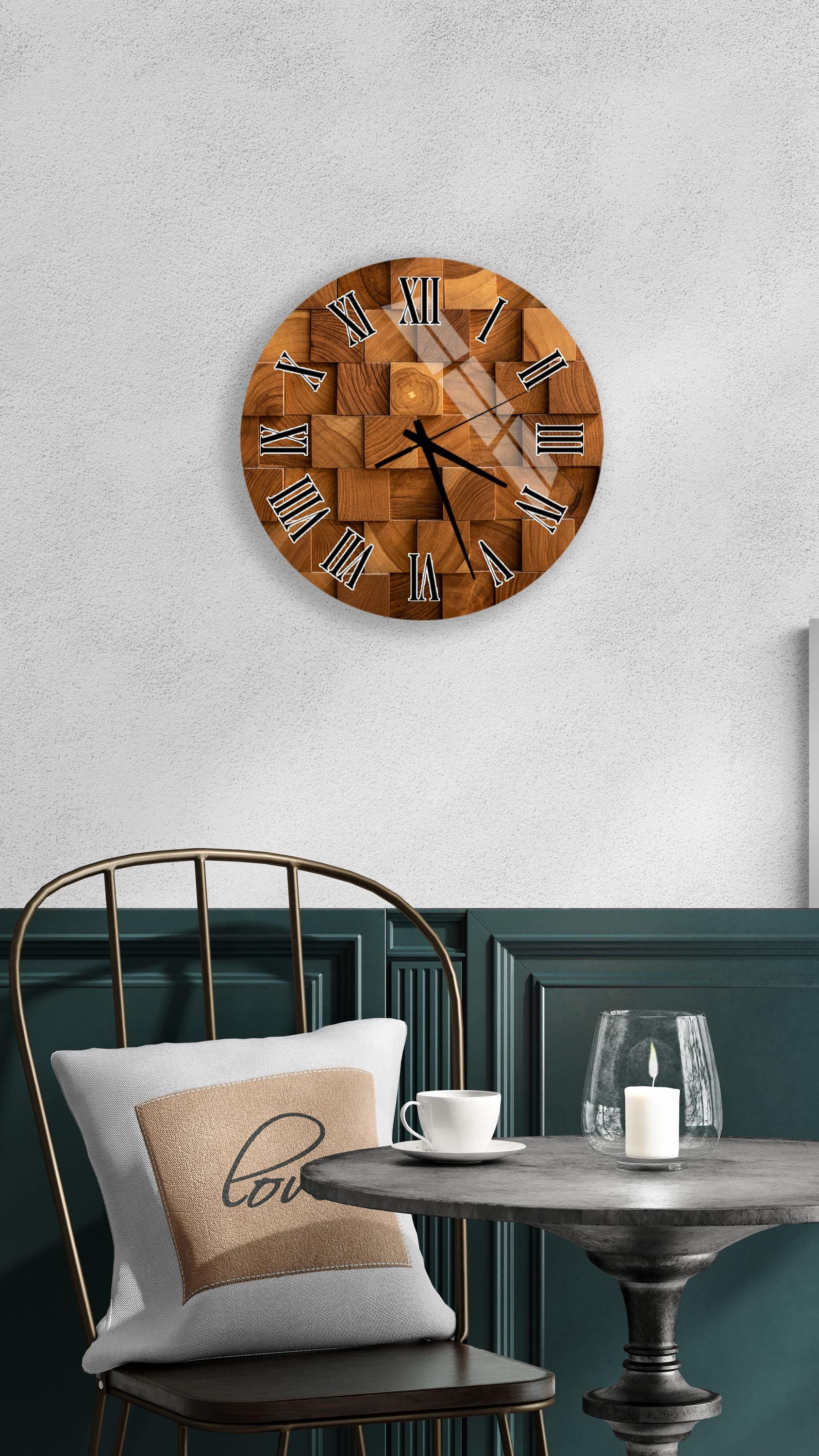 a wooden clock with Roman numerals mounted on a wall above a table with a white tablecloth and a candle.