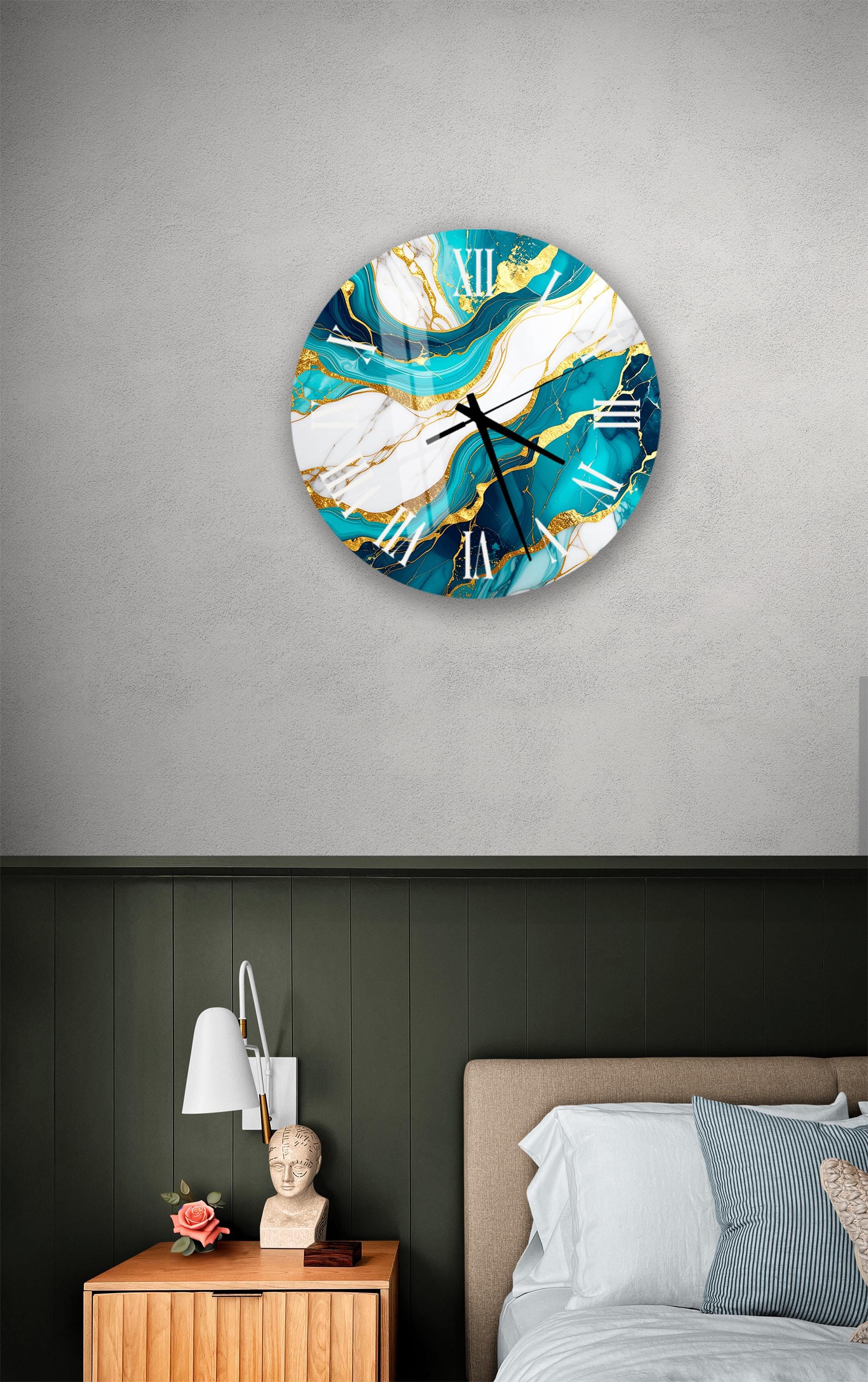 a bedroom setting with a large, round wall clock with a marble-like design in turquoise and white colors. The clock is mounted on a gray wall above a bed with a wooden headboard. The room also includes a nightstand with a lamp and a small statue or bust.