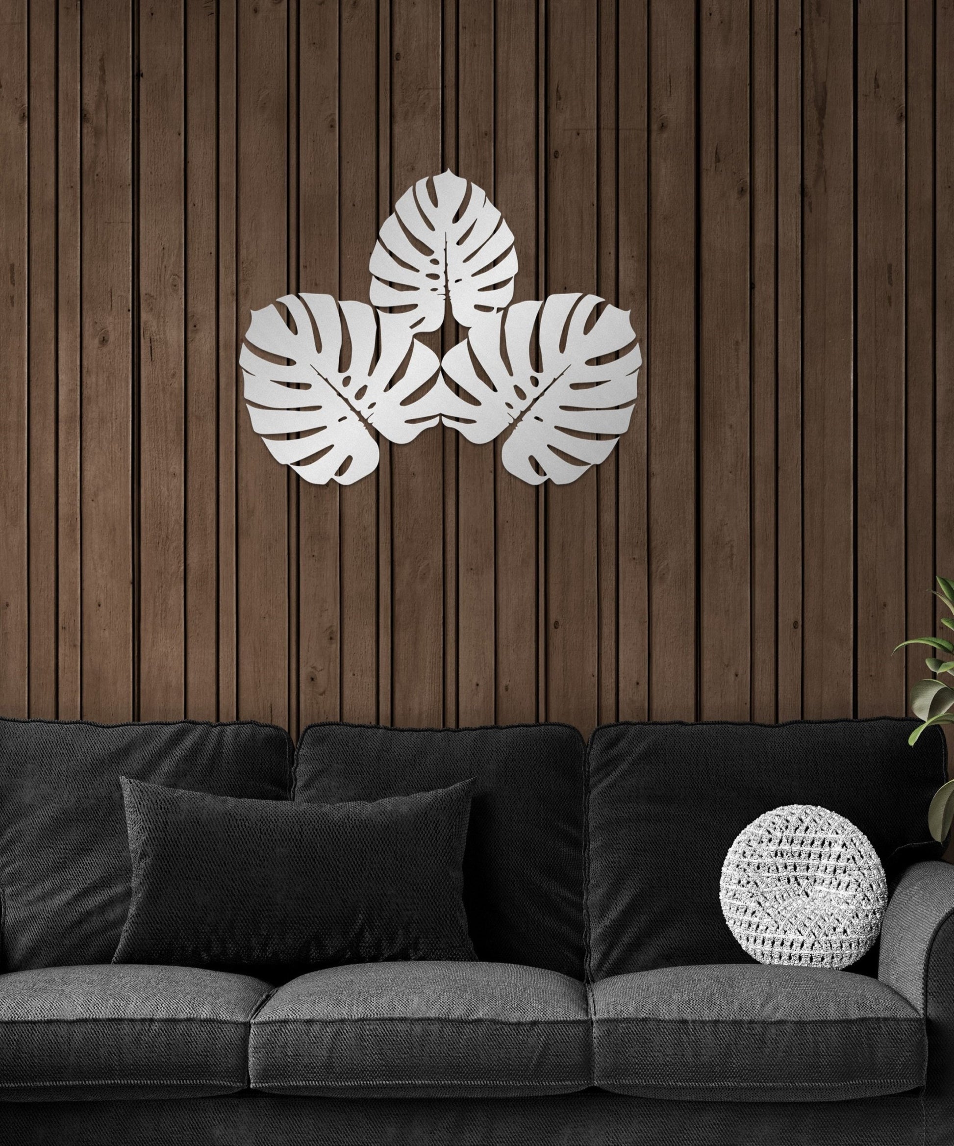 a living room with a black couch and a wooden wall