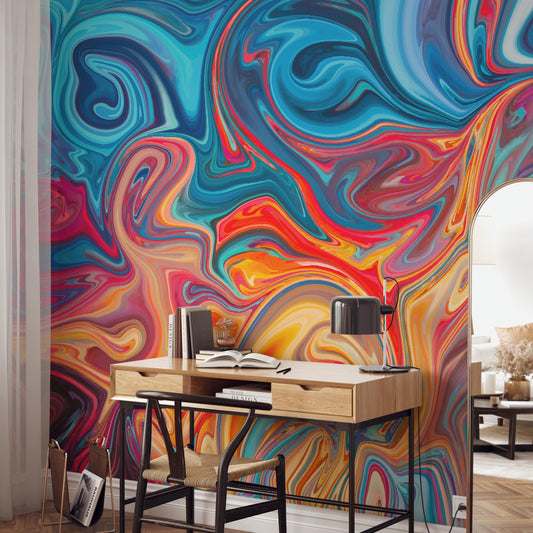 a vibrant, abstract mural with swirling patterns of blue, orange, and red colors on the wall behind a wooden desk with a laptop and books.