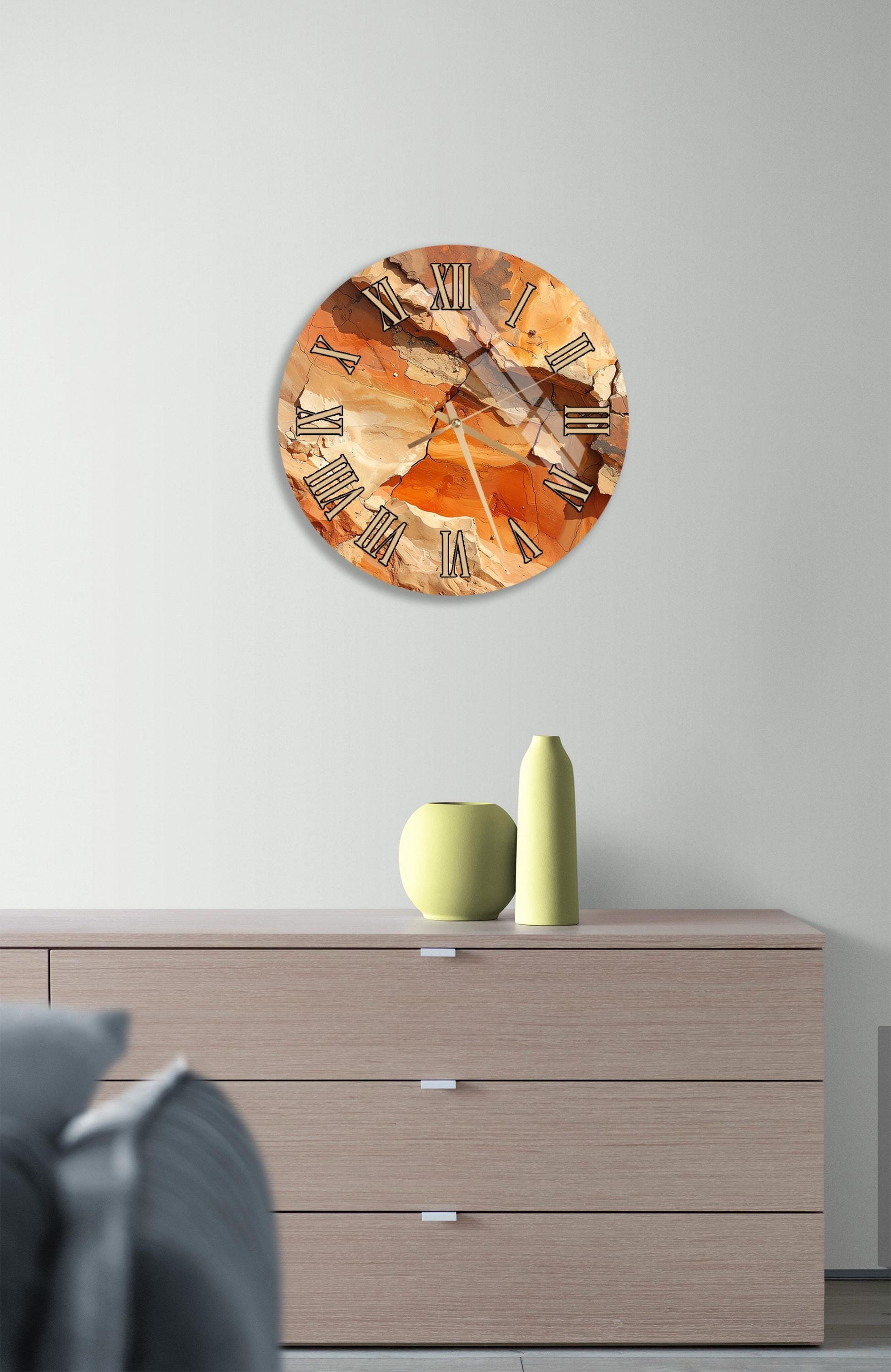 a wall clock with a unique, abstract design, mounted on a wall above a wooden dresser.
