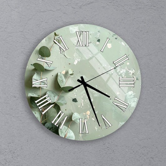 A round wall clock with a green and white color scheme, featuring Roman numerals and leaves as decorative elements.