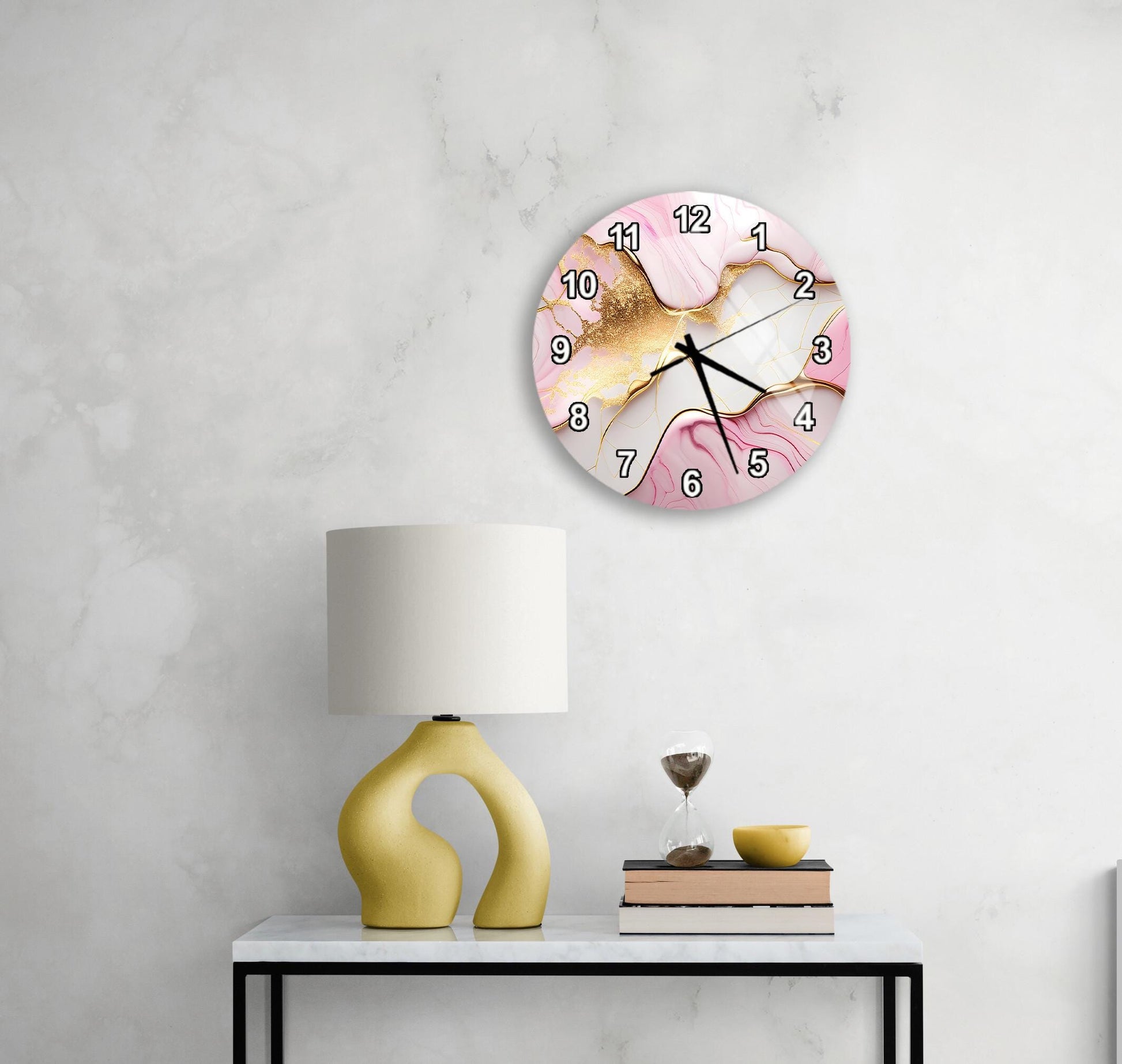 a white wall with a round clock displaying the time, a yellow lamp on a table, and a stack of books.