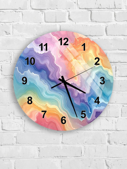 A colorful wall clock with a vibrant abstract design on its face, mounted on a white brick wall.