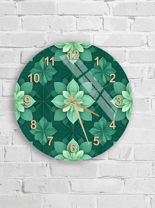 A wall clock with a green floral pattern and gold numbers is mounted on a white brick wall.