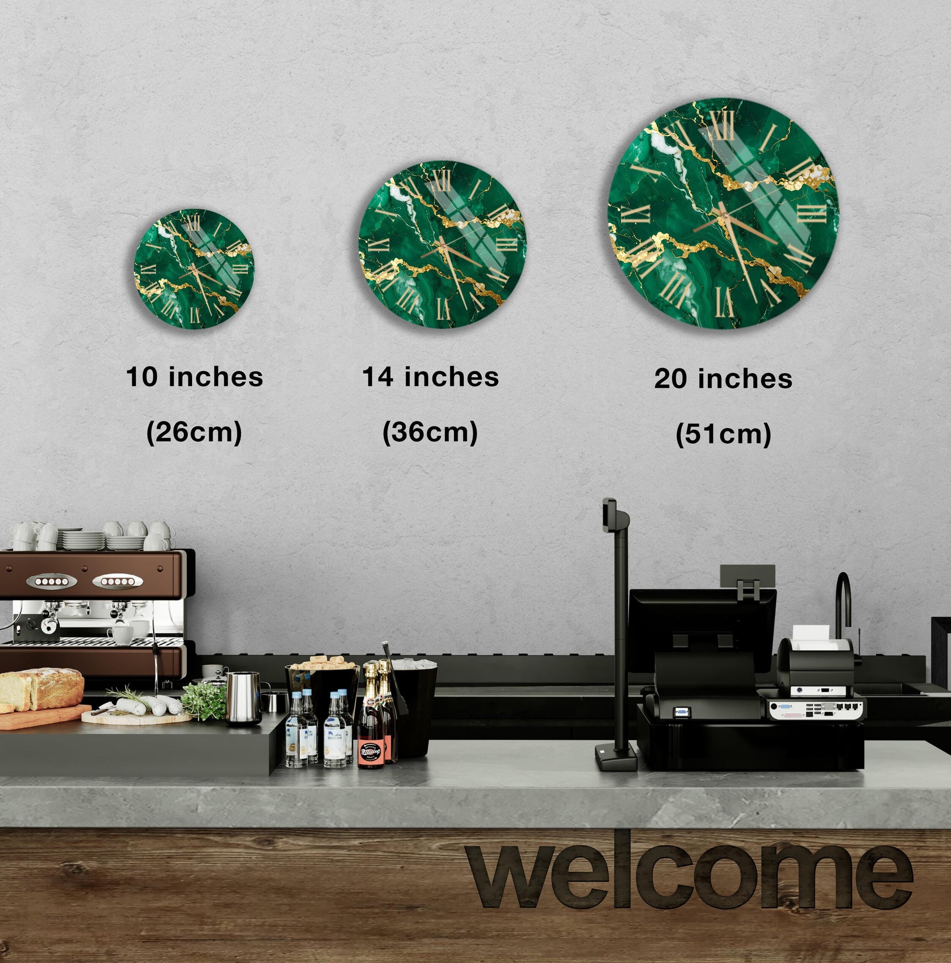 a wall clock with green and gold designs, and there are three different sizes of the clock displayed on the wall. In the foreground, there is a counter with various items such as bottles and a sandwich. The word "welcome" is written on the counter.