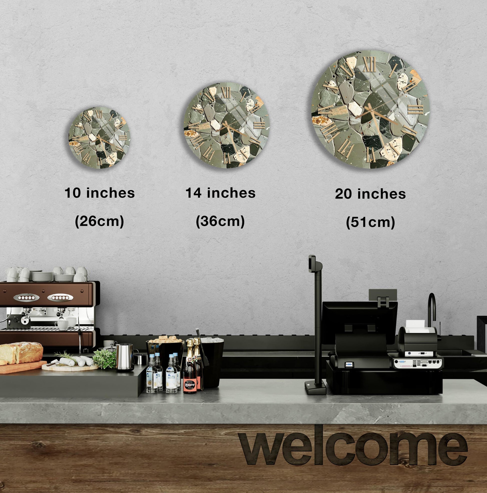 a counter in a restaurant with a "welcome" sign, and three different-sized round clock designs displayed on the wall above the counter.