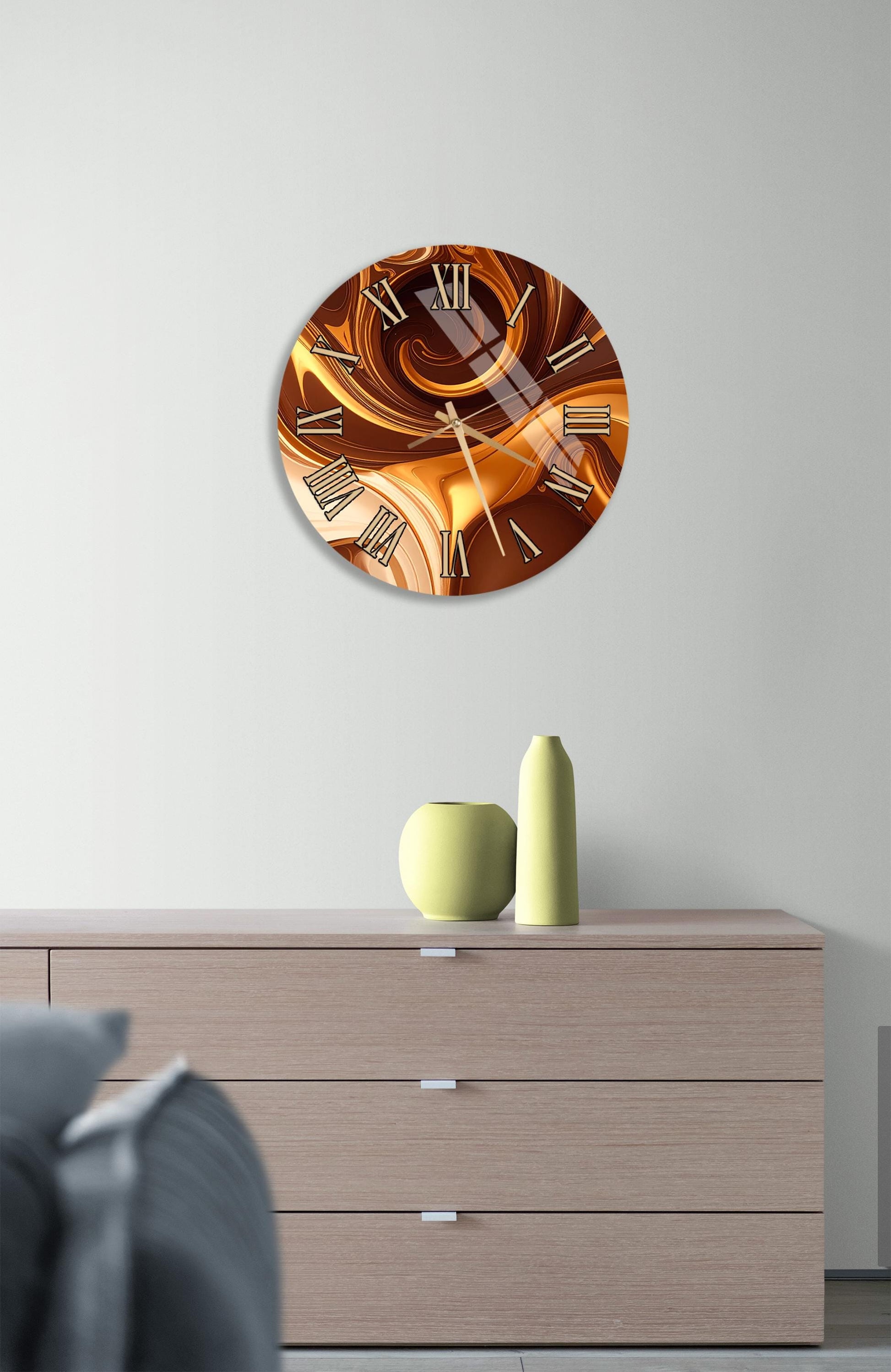 a modern clock with a swirling design on its face, mounted on a wall above a wooden dresser.