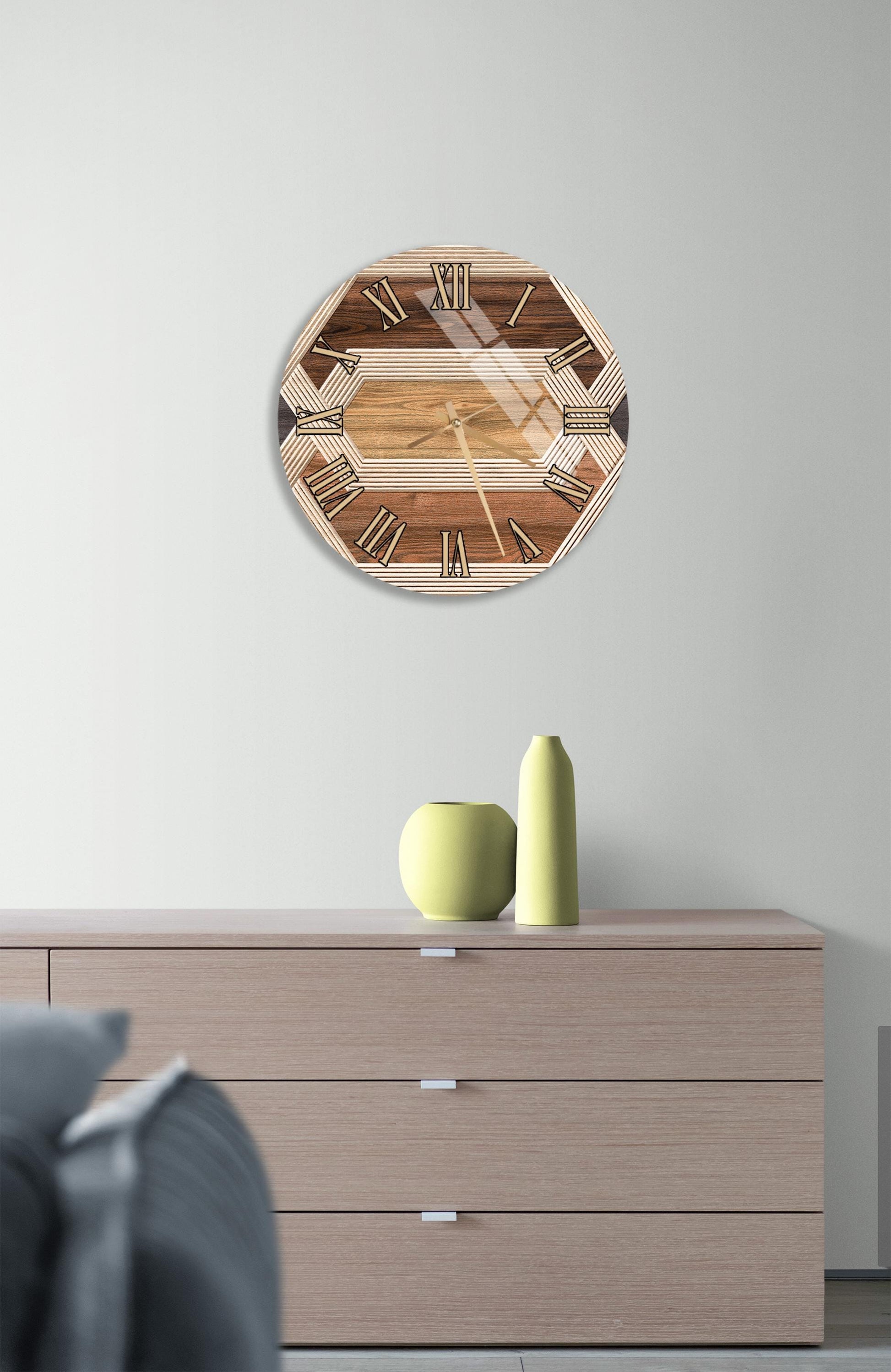 a wooden clock with a brown and white design, mounted on a wall above a wooden dresser with three drawers.
