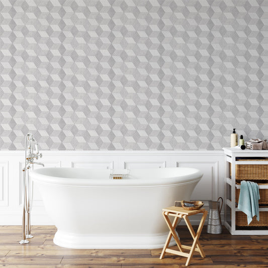 a modern bathroom with a white freestanding bathtub, a wooden stool, and a geometric gray and white patterned wallpaper.