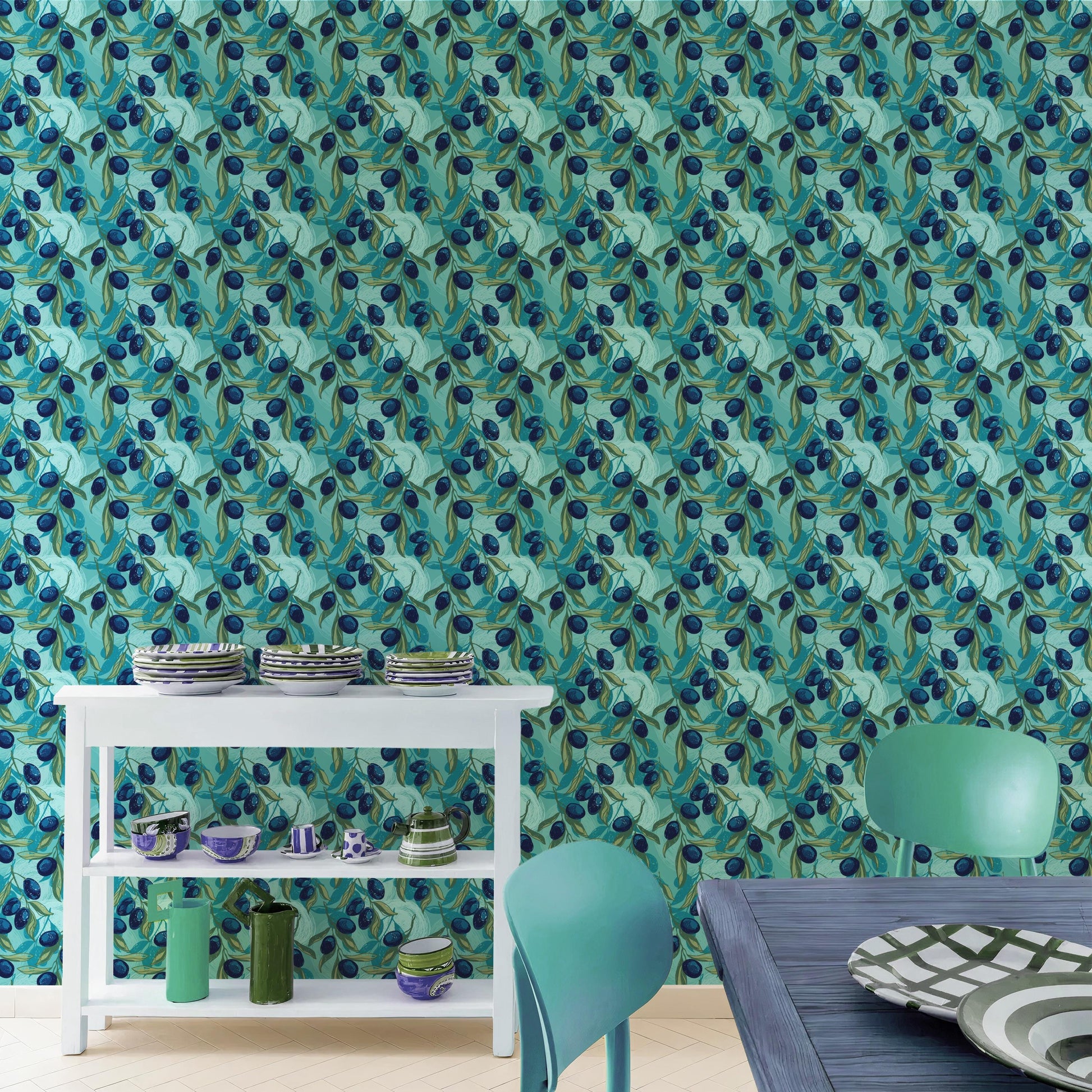 a dining area with a white table and chairs, a white shelf with plates and bowls, and a patterned wallpaper with a repeating design of blue and green leaves.