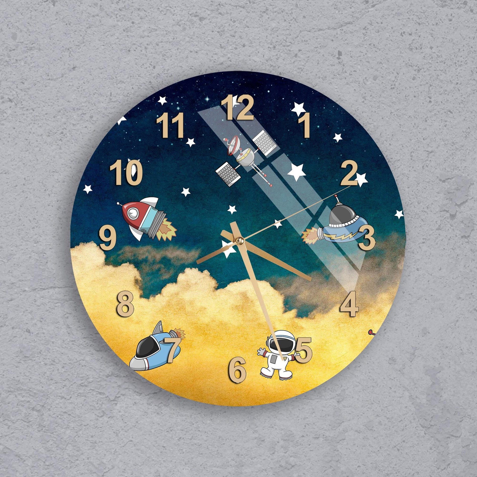 A wall clock with a space-themed design, featuring a rocket ship, a satellite, and an astronaut.
