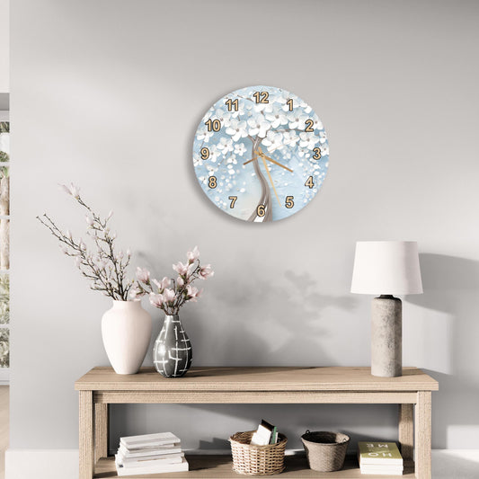 a wall clock with a floral design, a wooden table with a lamp, a vase with pink flowers, and some books on a shelf.