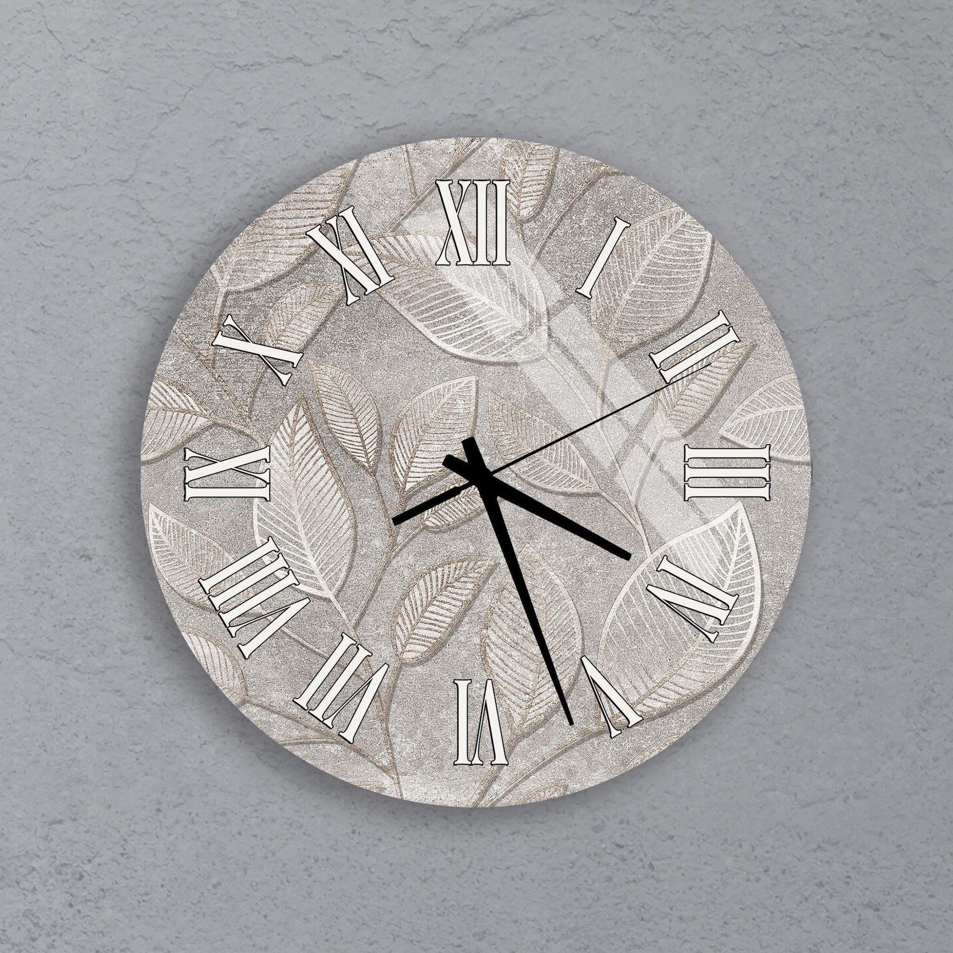 A wall clock with a leaf pattern design on its face.
