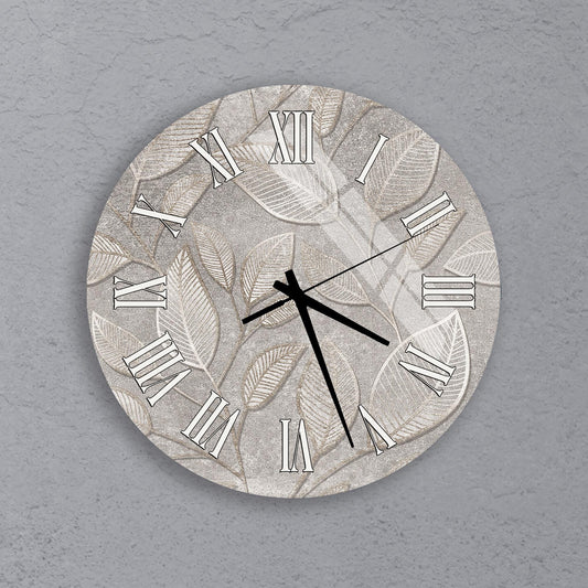 A wall clock with a leaf pattern design on its face.