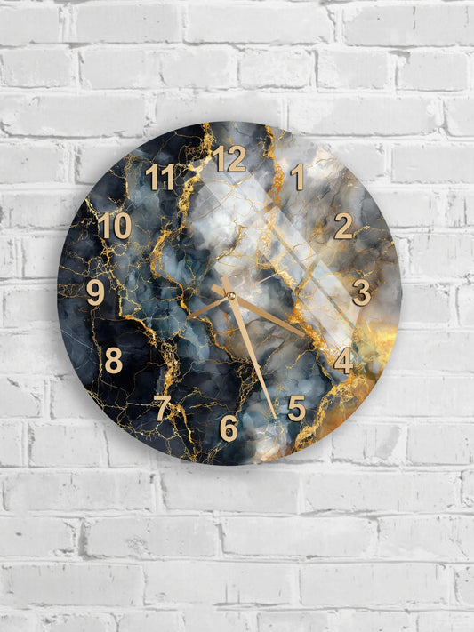 A round wall clock with a marble-like design and gold numbers is mounted on a white brick wall.