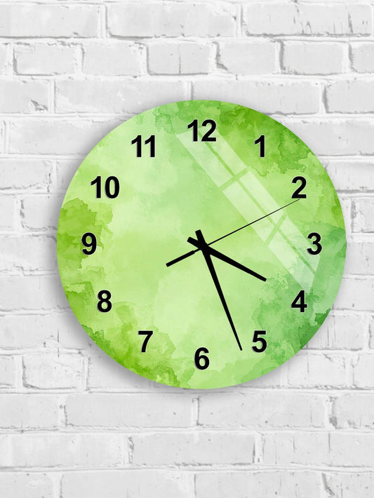 A green wall clock with black numbers and hands is mounted on a white brick wall.