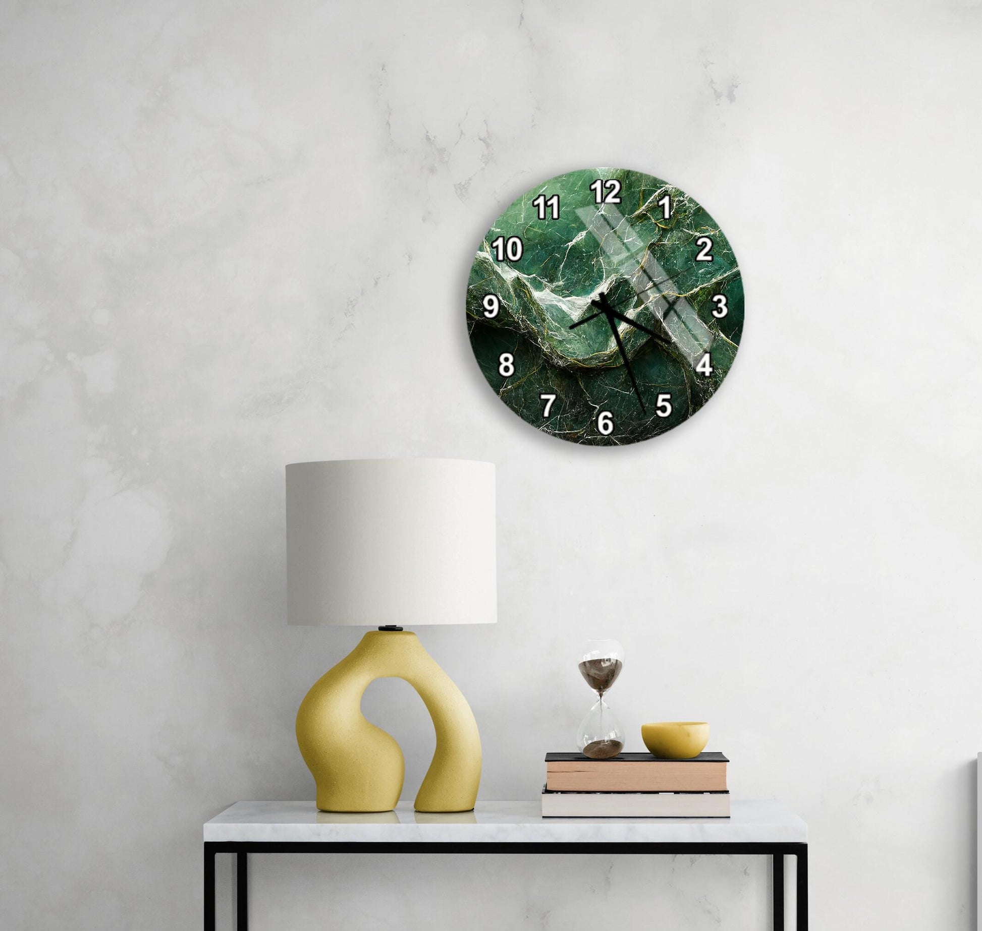 a modern living room with a white marble wall, a round clock with a green marble design, a yellow lamp with a unique curved base, and a small table with a book and a glass of water.