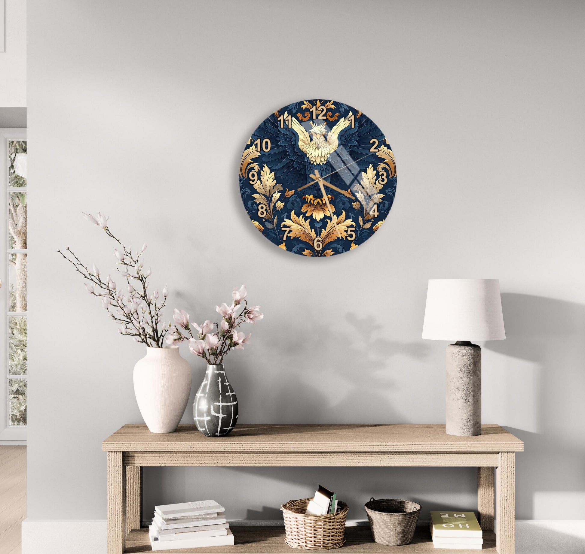 a wall clock with a blue and gold design, a wooden table with a lamp, a vase with flowers, and some books on a shelf.