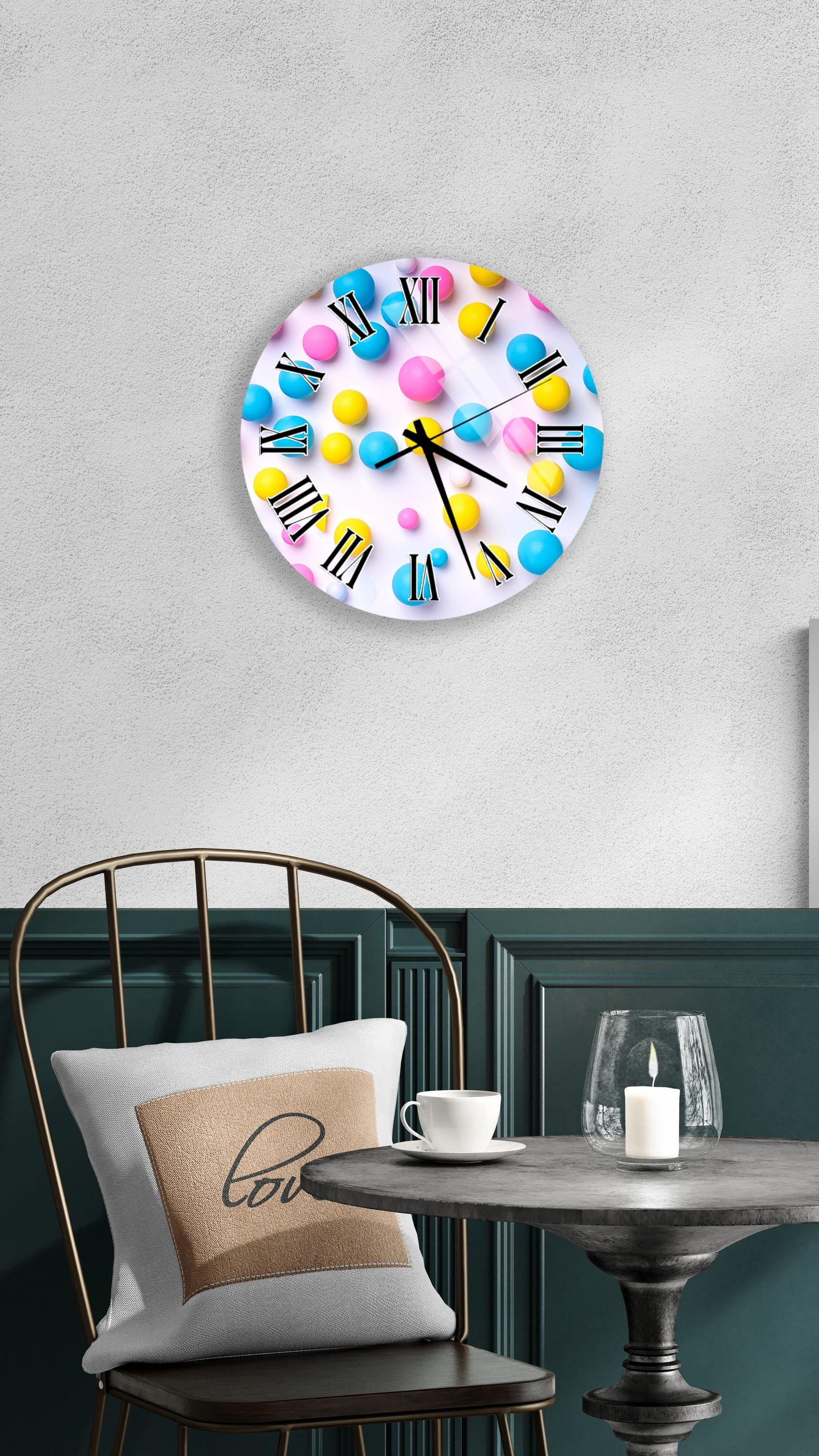 a wall clock with a colorful polka dot design, mounted on a wall above a table with a white tablecloth.