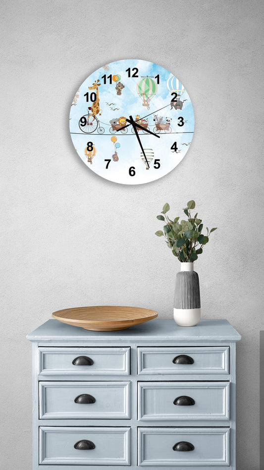 a clock with a cartoon-style design on a wall above a light blue dresser with six drawers. The clock has a playful design with various cartoon animals and objects, and the dresser has a vase with greenery on it.