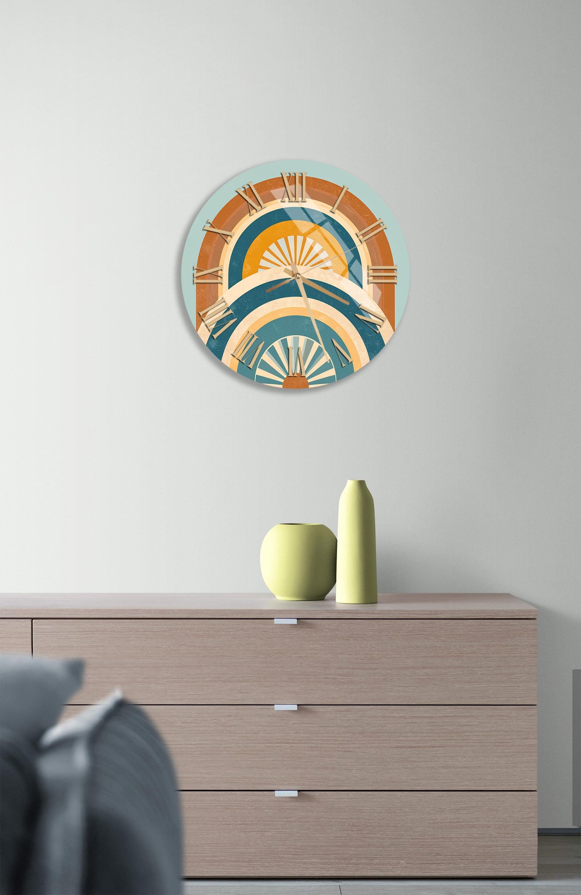 a modern living room with a wooden dresser, a round wall clock with a colorful abstract design, and a small vase on the dresser.
