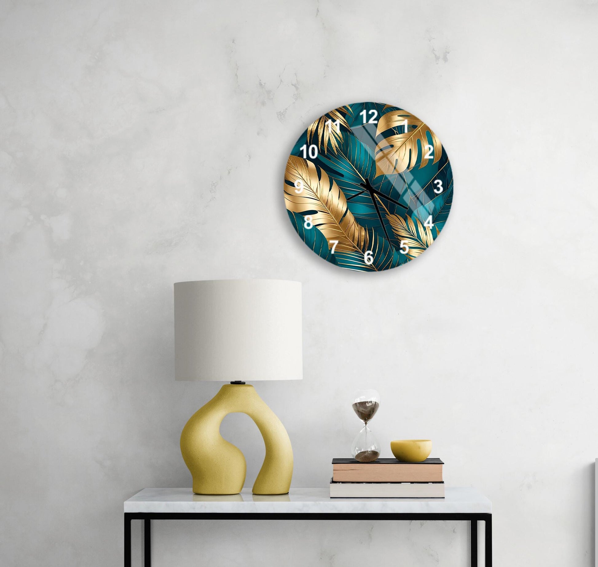 a modern living room with a round wall clock featuring a tropical leaf design in blue and gold colors, a yellow lamp with a unique curved base, and a small table with a book and a glass of wine.