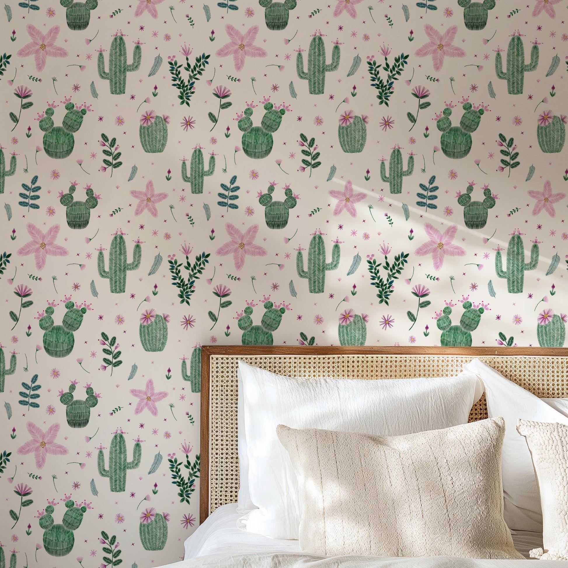 a bedroom with a wallpapered wall adorned with a repeating pattern of cacti and flowers in shades of pink and green. The wallpapered wall is complemented by a wooden headboard and a white bedding set, creating a cozy and inviting atmosphere.