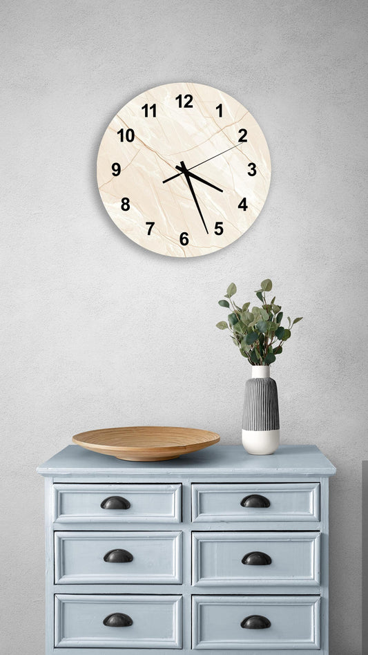 a wall clock with a white face and black numbers, mounted on a gray wall above a light blue wooden dresser with six drawers. The dresser also has a vase with greenery on it and a wooden plate on top.