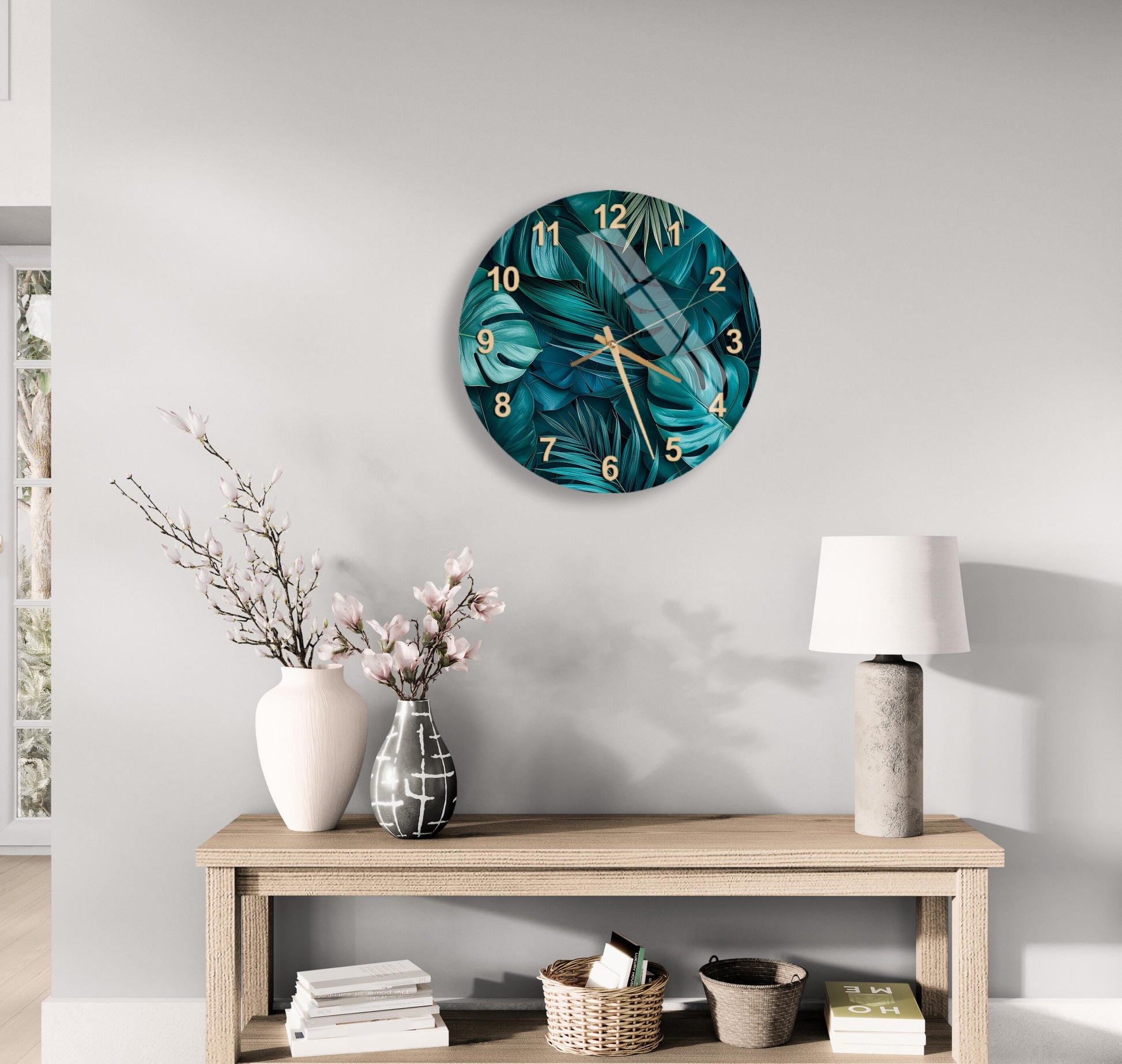 a modern living room with a large round wall clock displaying a tropical plant design, a wooden console table with a lamp, a vase with flowers, and a stack of books.