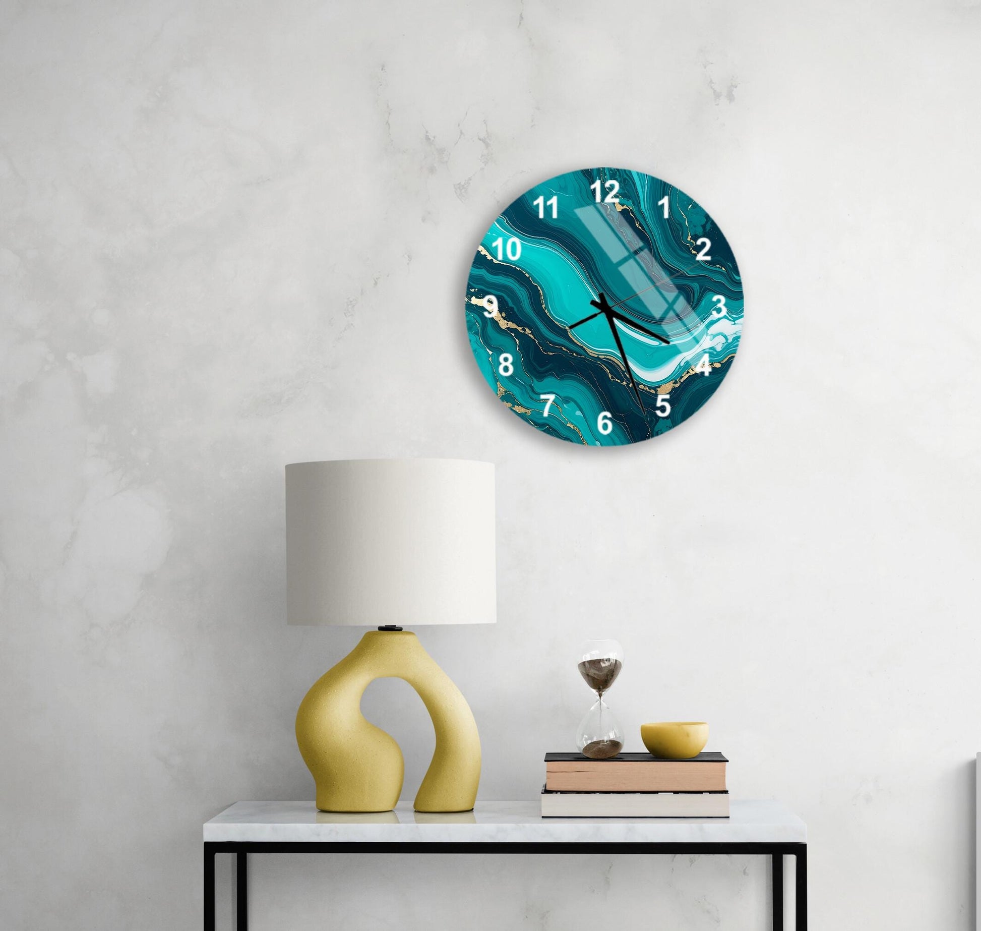 a modern living room with a white marble wall, a round wall clock with a turquoise marble design, a yellow lamp with a unique curved base, a stack of books, and a glass of wine on a white table.