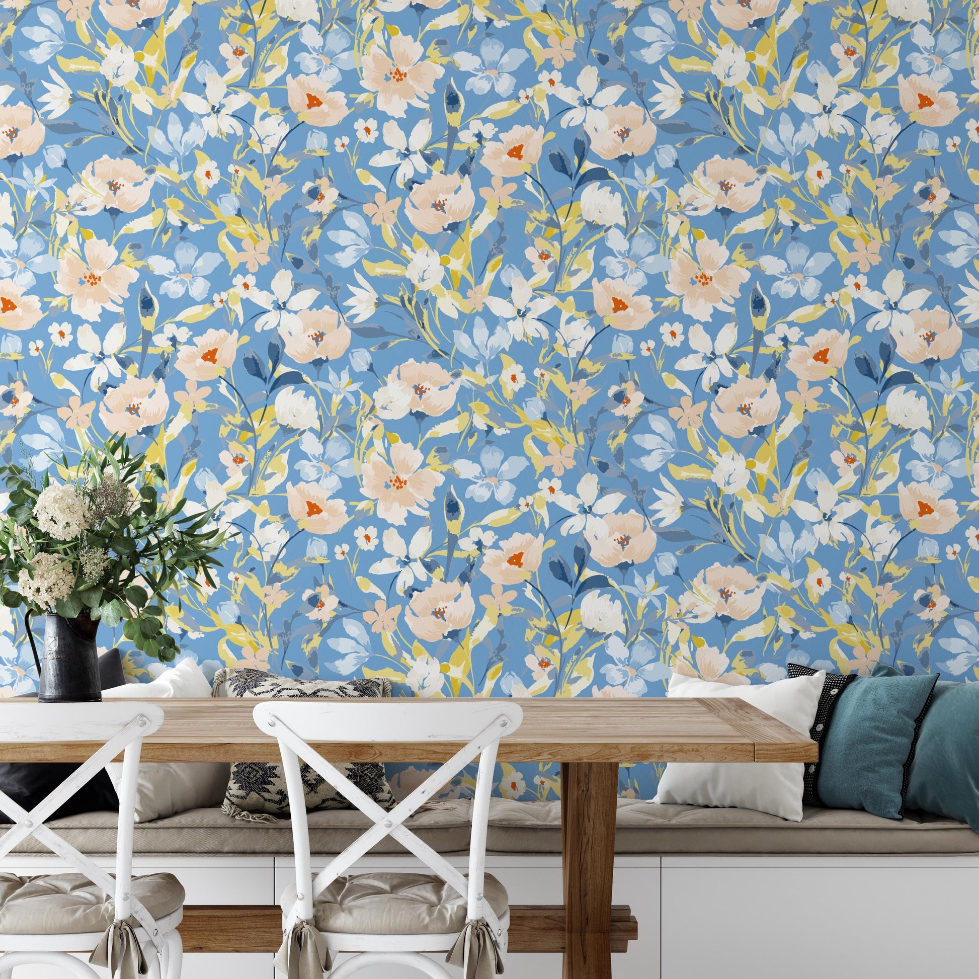 a dining area with a wooden table and chairs, a vase of flowers, and a blue floral wallpaper behind the table.