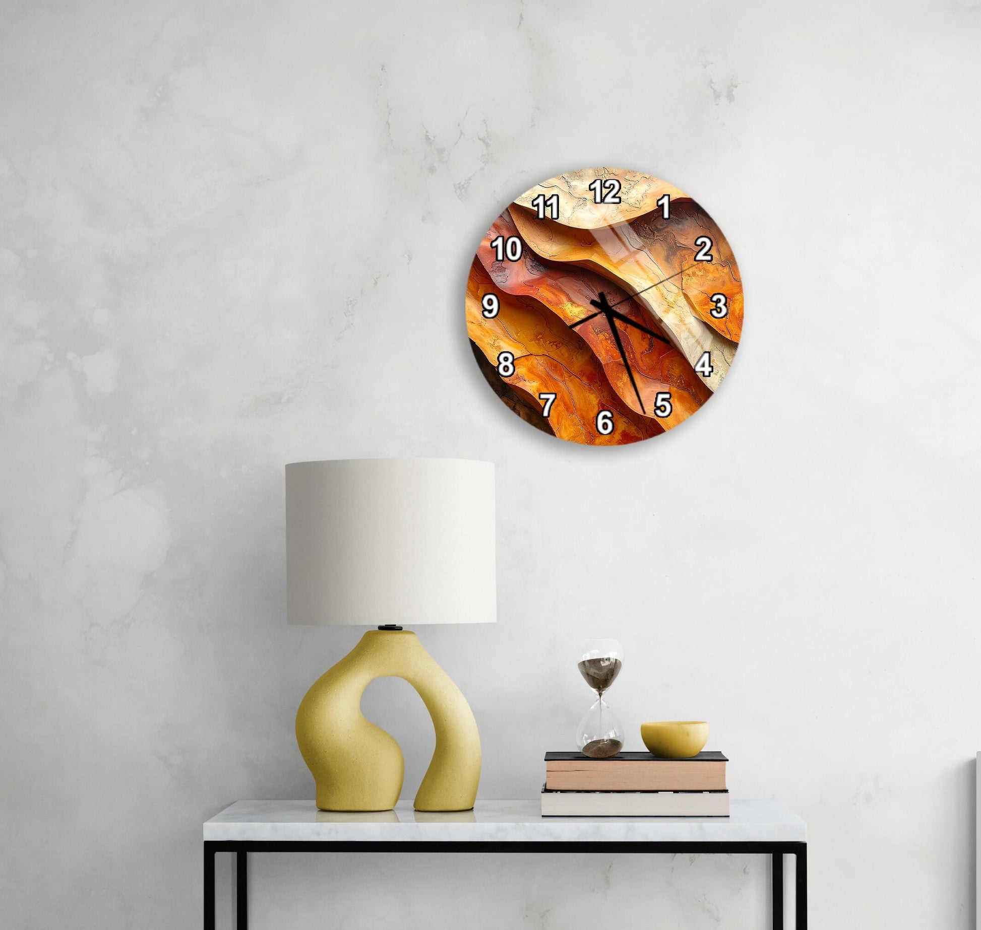 a modern living room with a round clock on the wall, a yellow lamp on a table, and a stack of books.