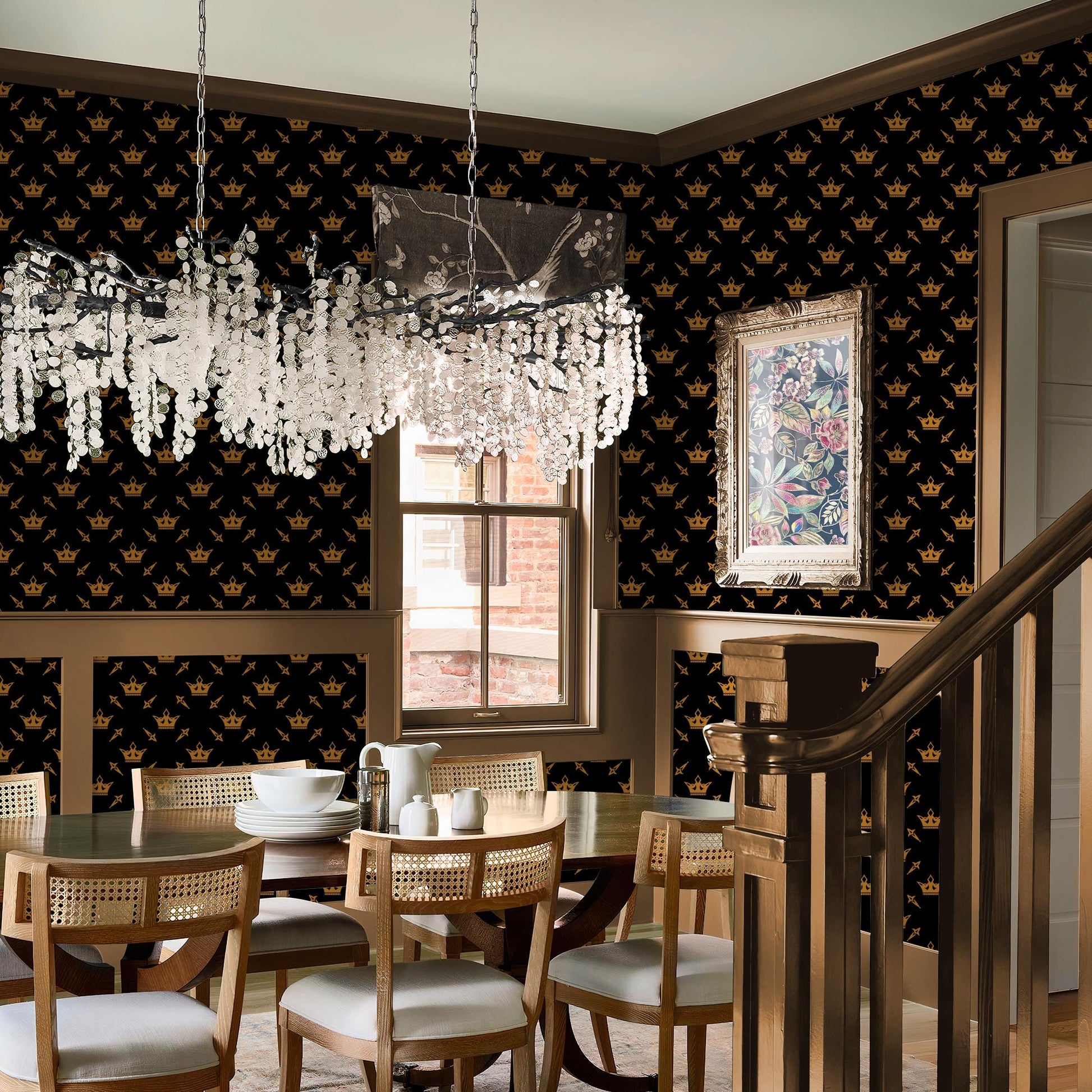 a luxurious dining room with a black and gold patterned wallpaper, a chandelier, and a wooden staircase.