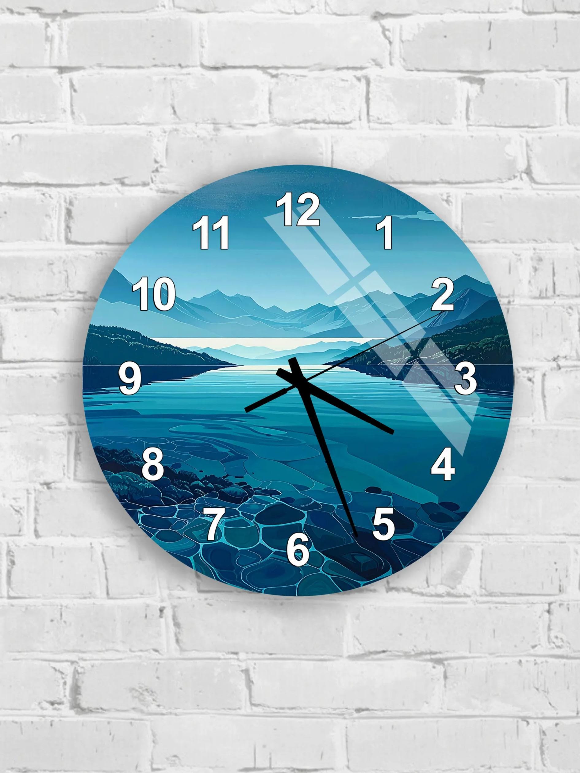 A wall clock with a serene landscape of mountains, water, and a lake on its face, mounted on a white brick wall.