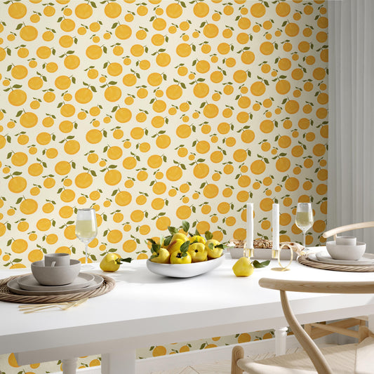 a dining table set with a bowl of fruit, glasses, and a plate, all against a wall with a repeating pattern of yellow and green circles.