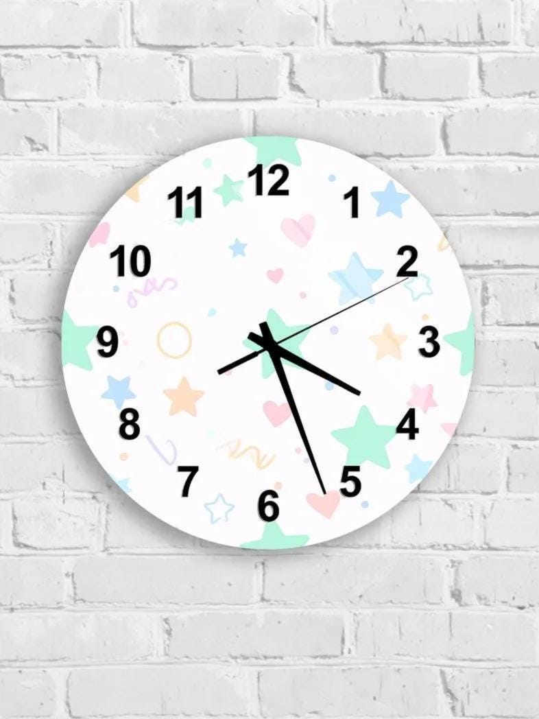 A round wall clock with a white face and colorful star and heart designs.