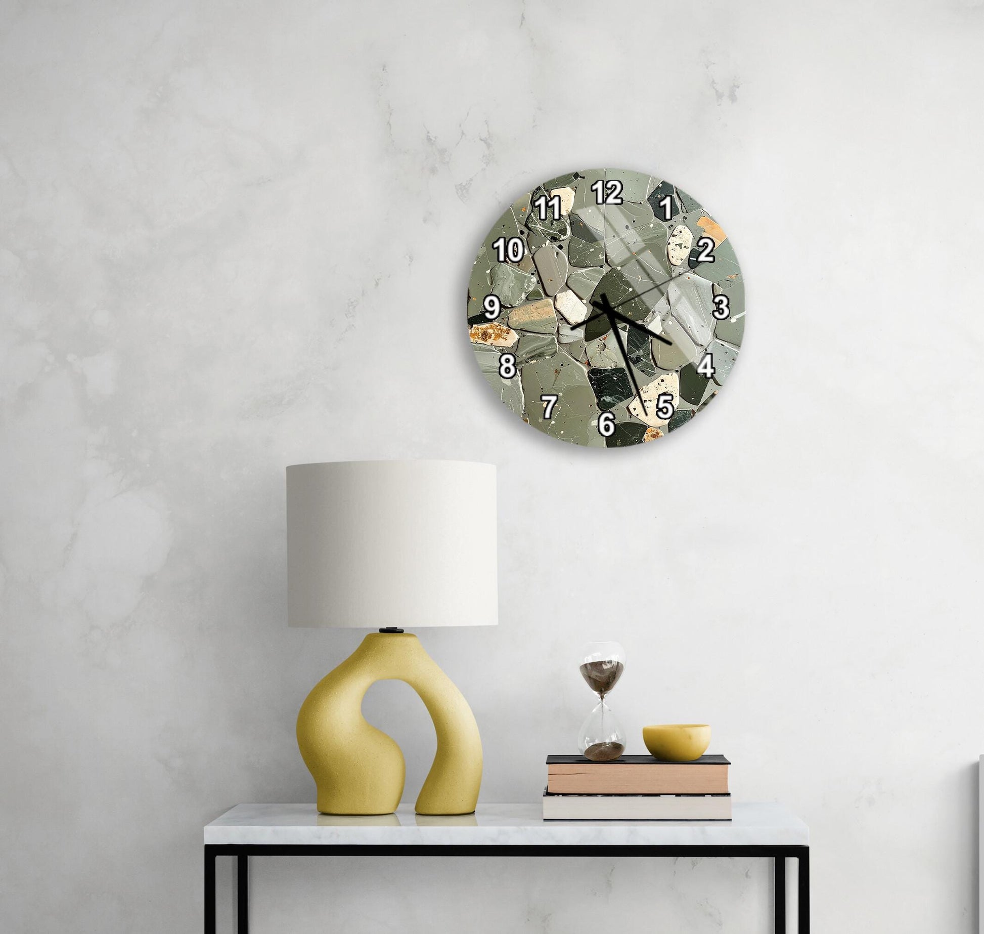 a modern living room with a white marble wall, a round clock with a unique design, a yellow lamp with a curved base, a stack of books, and a glass of wine on a white table.