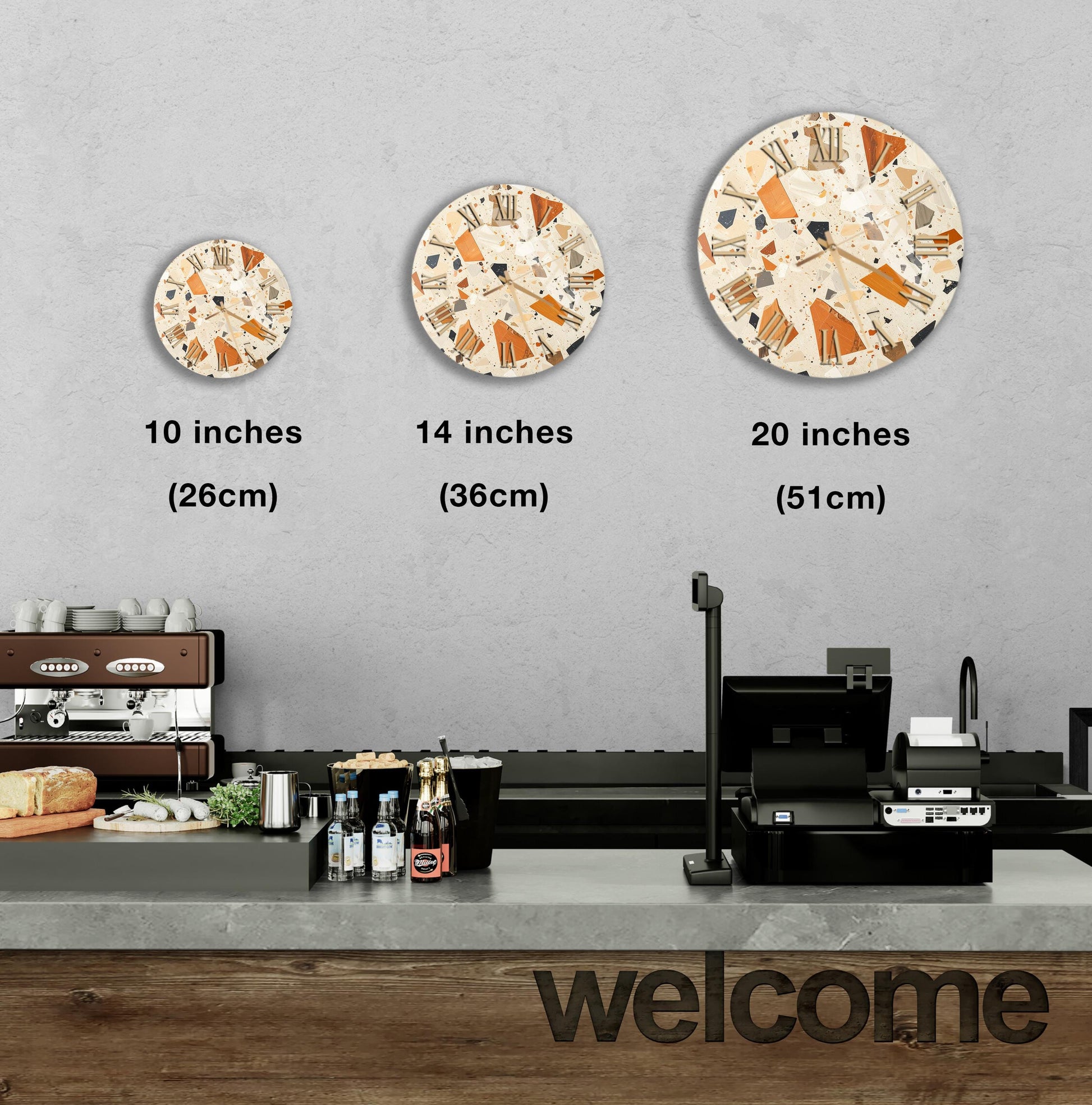 a wall with three different clock designs, each with a different size and style, and a counter with various items on it, such as bottles and a sandwich.