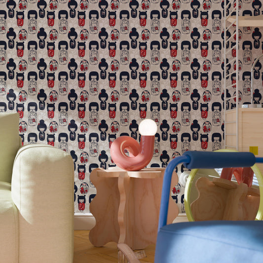 a room with a patterned wallpaper, a pink sculpture on a wooden table, and a blue chair.
